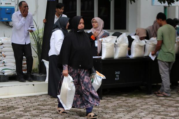 Keluarga Penerima Manfaat (KPM) membawa karung berisi beras saat berlangsung penyaluran bantuan pangan di kantor Camat Lueng Bata, Banda Aceh, Aceh, Rabu (16/7/2025). Badan Pangan Nasional menargetkan sebanyak 18,27 juta Penerima Bantuan Pangan (PBP) untuk alokasi Juni dan Juli 2025 dengan total penyaluran beras sebanyak 20 kg atau 10 kg per bulan per KPM, guna membantu perekonomian masyarakat kurang mampu.