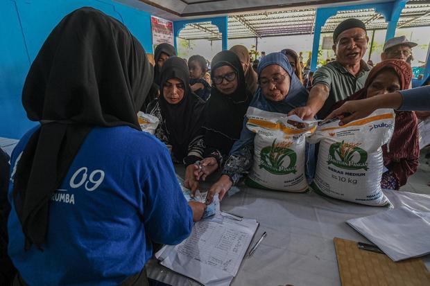 Warga mengantre untuk menerima bantuan beras di Kantor Lurah Korumba, Kendari, Sulawesi Tenggara, Kamis (17/7/2025). Pemkot Kendari menyalurkan sebanyak 353,5 ton cadangan beras pemerintah (CBP) untuk periode Juni-Juli 2025 bagi 17.676 keluarga yang tercatat sebagai penerima manfaat guna mengendalikan gejolak harga beras yang terjadi di wilayah itu.