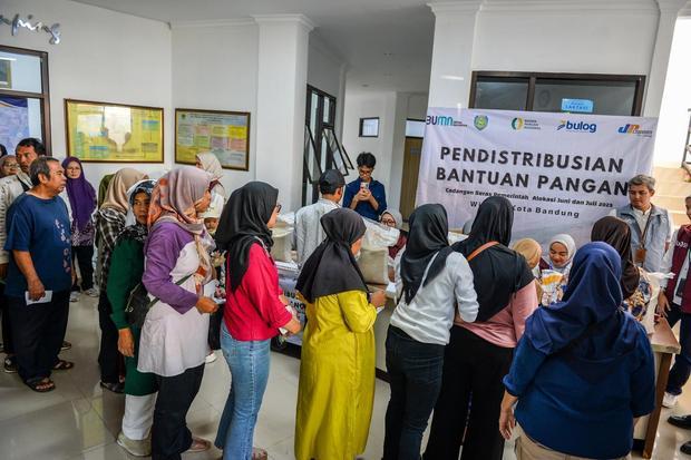 Warga antre saat pendistribusian bantuan cadangan pangan di Kelurahan Cihapit, Bandung, Jawa Barat, Jumat (18/7/2025). Pemerintah Kota Bandung menyalurkan bantuan cadangan pangan dari Badan Pangan Nasional (Bapanas) berupa 10 kilogram beras kepada 85.167 warga di 151 yang ada kelurahan di Kota Bandung.