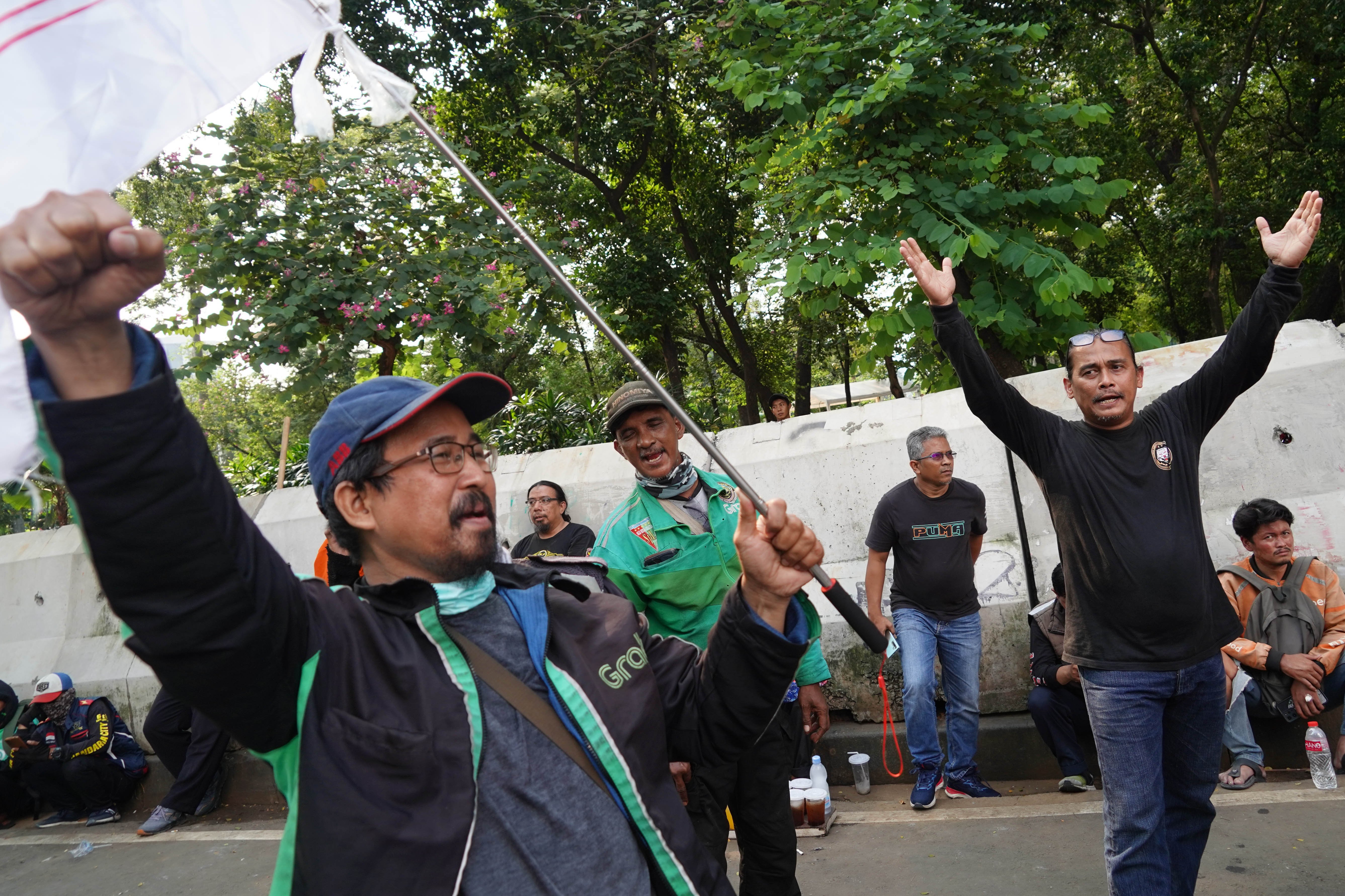 Pengemudi ojek online (ojol) yang tergabung dalam Gabungan Aksi Roda Dua (Garda) melakukan demonstrasi di Jalan Merdeka Selatan, Jakarta Pusat, Senin (21/7/2025). Aksi tersebut digelar untuk mendesak pemerintah dalam membuat UU Transportasi Online dan menurunkan potongan aplikator atas layanan pengantaran orang dari 20% menjadi 10% serta menghapus program aplikator seperti hemat, aceng dan slot.