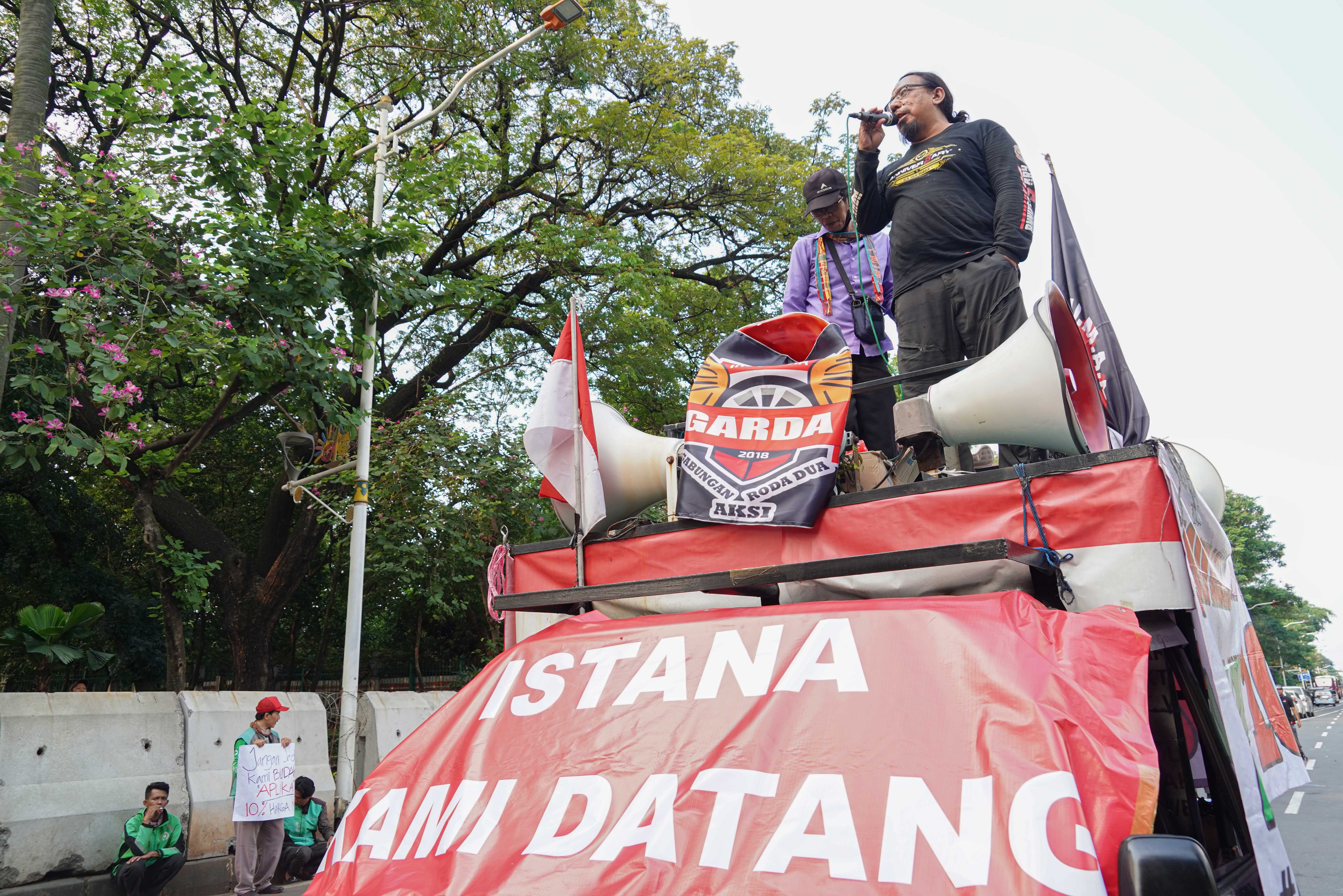 Pengemudi ojek online (ojol) yang tergabung dalam Gabungan Aksi Roda Dua (Garda) melakukan demonstrasi di Jalan Merdeka Selatan, Jakarta Pusat, Senin (21/7/2025). Aksi tersebut digelar untuk mendesak pemerintah dalam membuat UU Transportasi Online dan menurunkan potongan aplikator atas layanan pengantaran orang dari 20% menjadi 10% serta menghapus program aplikator seperti hemat, aceng dan slot.