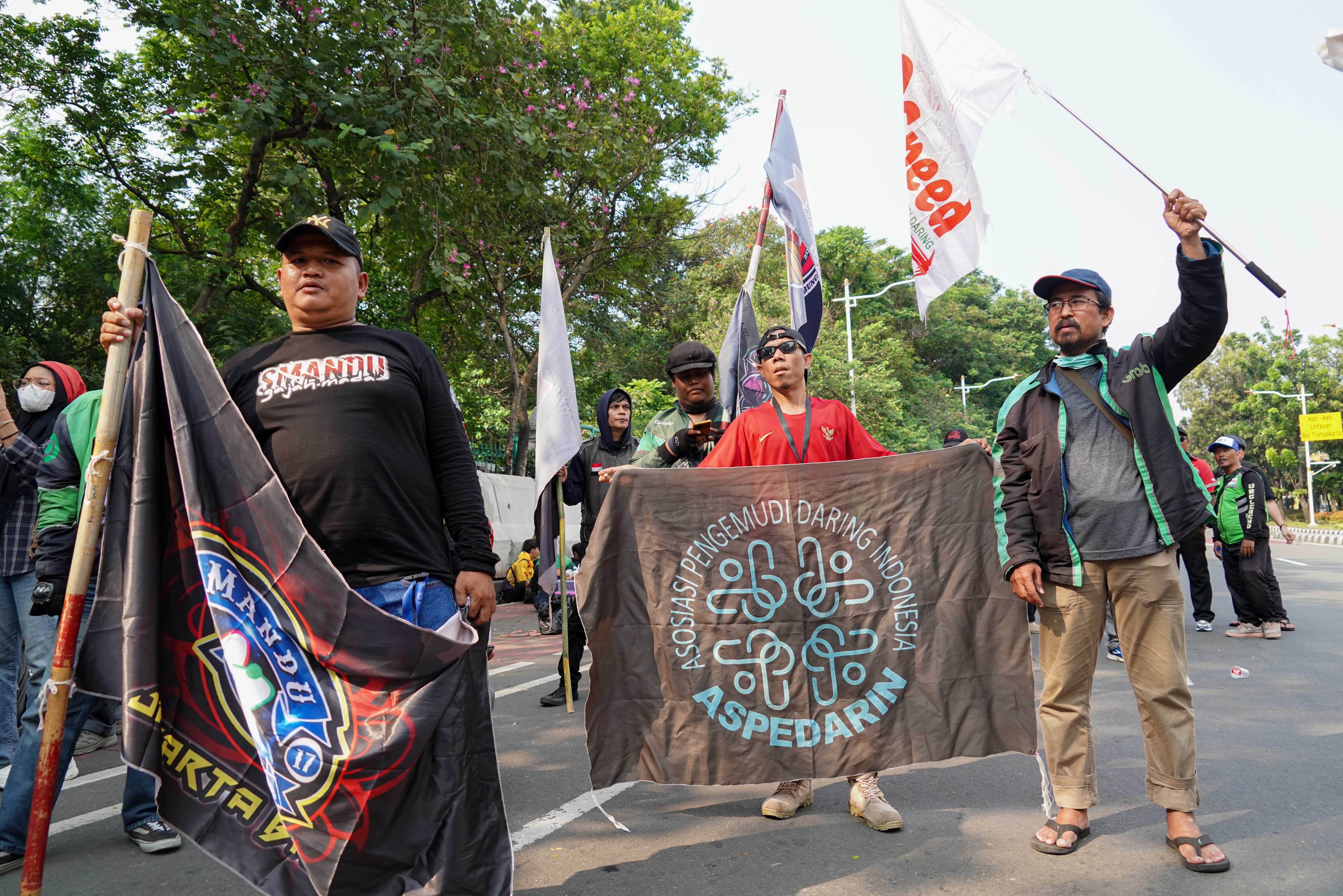 Pengemudi ojek online (ojol) yang tergabung dalam Gabungan Aksi Roda Dua (Garda) melakukan demonstrasi di Jalan Merdeka Selatan, Jakarta Pusat, Senin (21/7/2025). Aksi tersebut digelar untuk mendesak pemerintah dalam membuat UU Transportasi Online dan menurunkan potongan aplikator atas layanan pengantaran orang dari 20% menjadi 10% serta menghapus program aplikator seperti hemat, aceng dan slot.