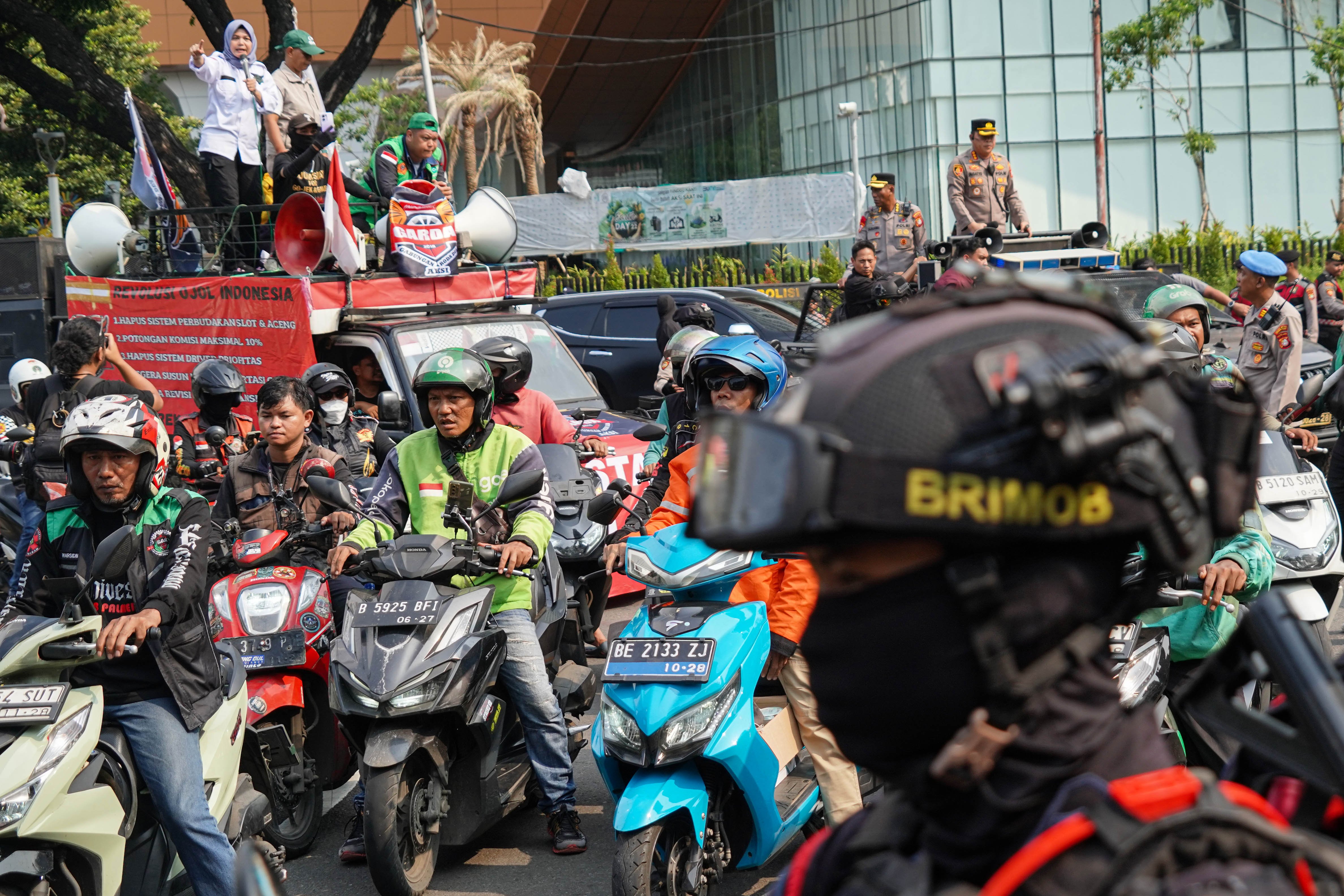 Pengemudi ojek online (ojol) yang tergabung dalam Gabungan Aksi Roda Dua (Garda) melakukan demonstrasi di Jalan Merdeka Selatan, Jakarta Pusat, Senin (21/7/2025). Aksi tersebut digelar untuk mendesak pemerintah dalam membuat UU Transportasi Online dan menurunkan potongan aplikator atas layanan pengantaran orang dari 20% menjadi 10% serta menghapus program aplikator seperti hemat, aceng dan slot.