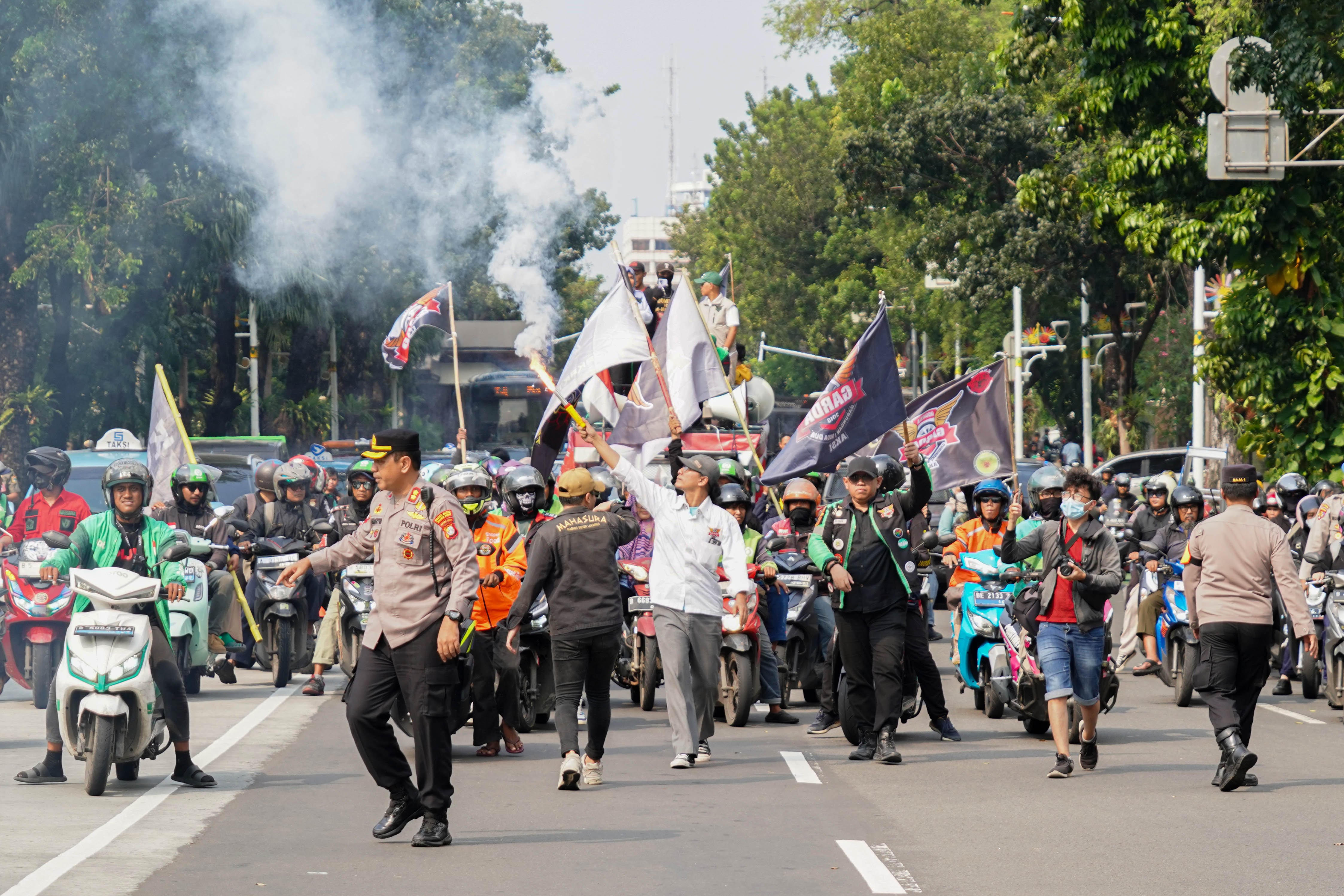 Pengemudi ojek online (ojol) yang tergabung dalam Gabungan Aksi Roda Dua (Garda) melakukan demonstrasi di Jalan Merdeka Selatan, Jakarta Pusat, Senin (21/7/2025). Aksi tersebut digelar untuk mendesak pemerintah dalam membuat UU Transportasi Online dan menurunkan potongan aplikator atas layanan pengantaran orang dari 20% menjadi 10% serta menghapus program aplikator seperti hemat, aceng dan slot.