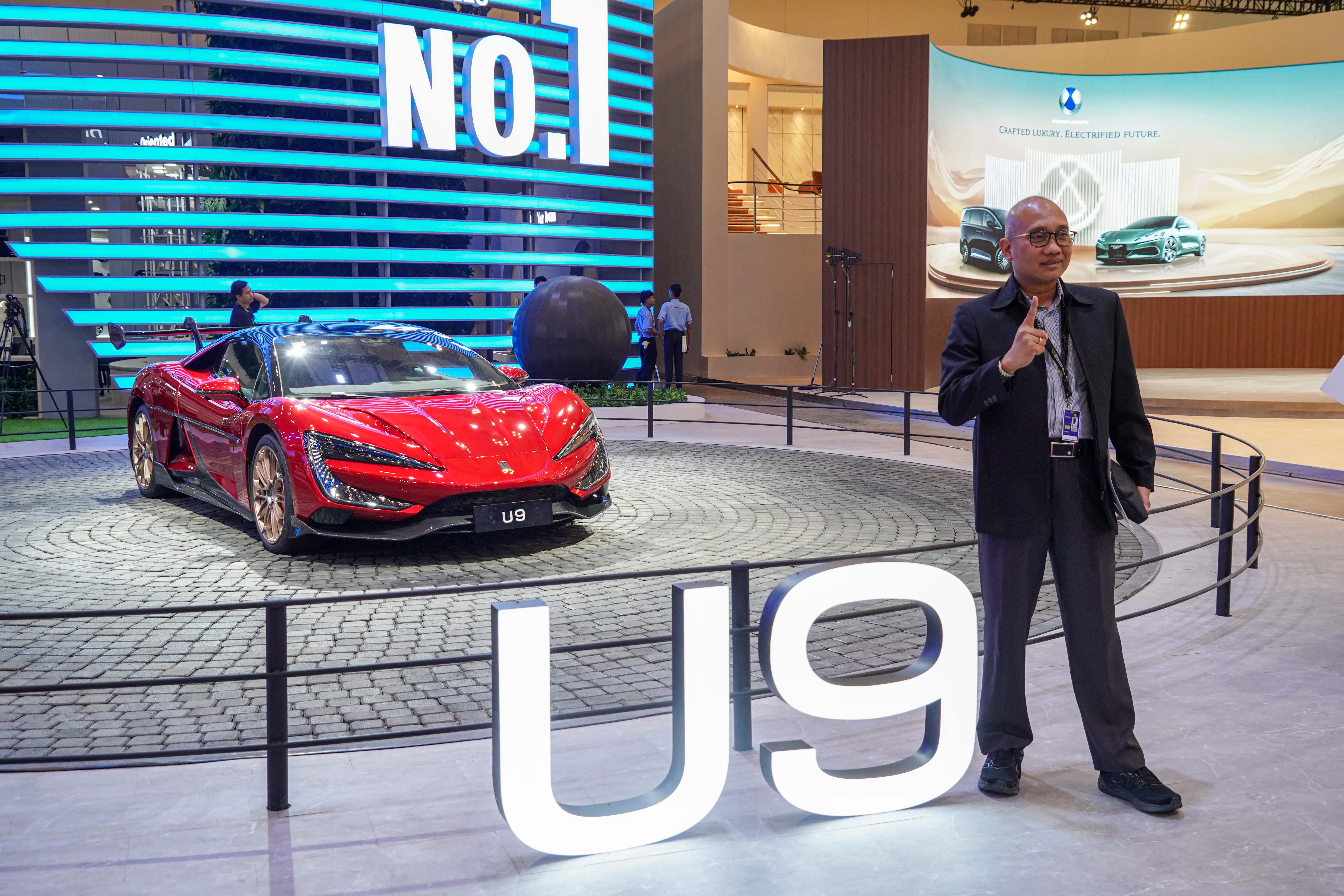 Pengunjung berfoto dengan mobil BYD U9 yang dipamerkan di Gaikindo Indonesia International Auto Show (GIIAS) 2025 di Indonesia Convention Exhibition (ICE), BSD City, Kabupaten Tangerang, Rabu (23/7/2025). Pameran yang mengusung tema \
