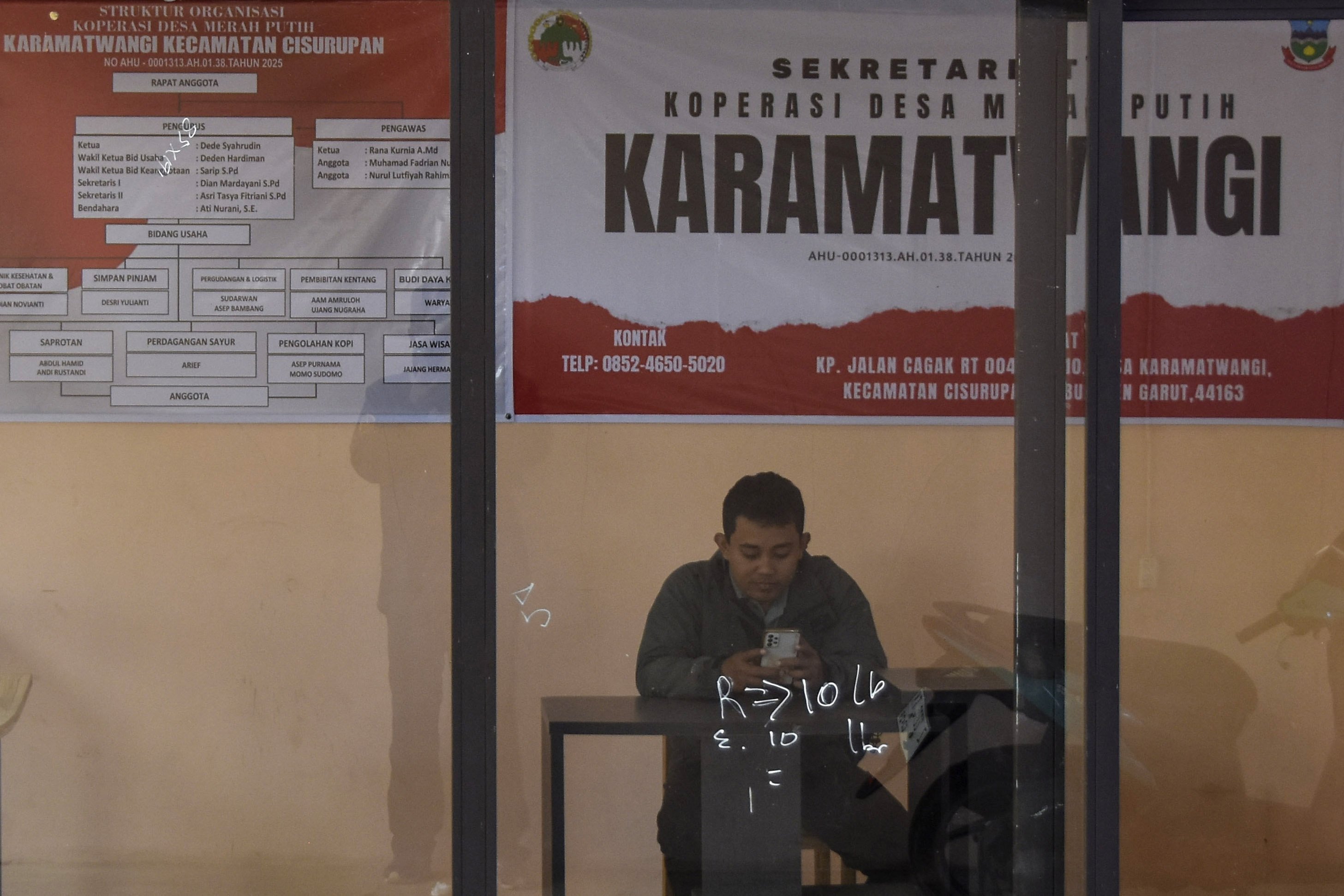 Pegawai menunggu anggota koperasi di Kantor Kesekretariatan Koperasi Merah Putih Karamatwangi Desa Karamatwangi, Kecamatan Cisurupan, Kabupaten Garut, Jawa Barat.