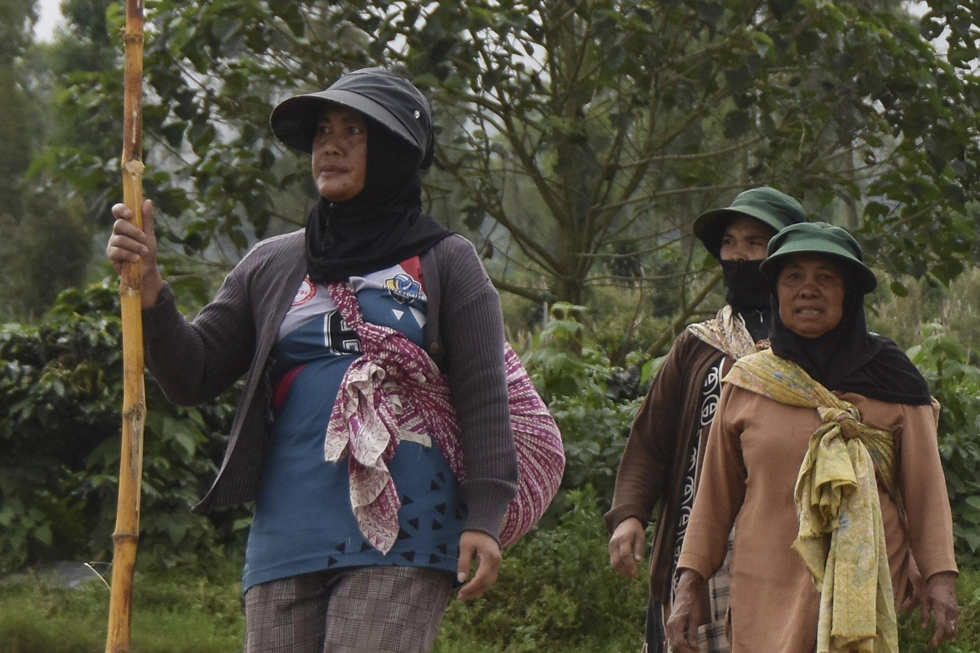 Petani berjalan menuju ladang untuk bercocok tanam di Desa Karamatwangi, Kecamatan Cisurupan, Kabupaten Garut, Jawa Barat.