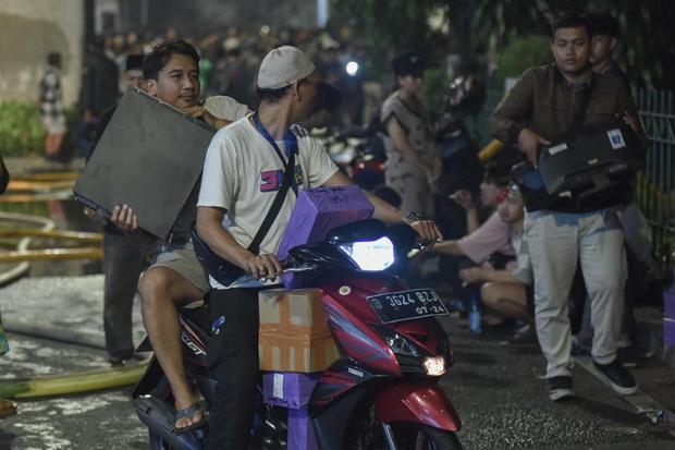 Pedagang menyelamatkan barang dagangan pada kebakaran di Pasar Taman Puring, Kebayoran Baru, Jakarta Selatan, Senin (28/7/2025). Menurut Sudin Gulkarmat kebakaran terjadi pada pukul 18.02 WIB dan sebanyak enam unit mobil damkar dikerahkan untuk memadamkan api yang penyebabnya masih dalam penyelidikan.