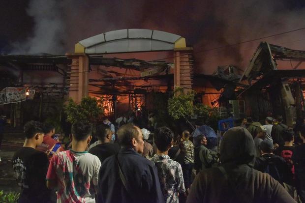Warga mengamati kebakaran di Pasar Taman Puring, Kebayoran Baru, Jakarta Selatan, Senin (28/7/2025). Menurut Sudin Gulkarmat kebakaran terjadi pada pukul 18.02 WIB dan sebanyak enam unit mobil damkar dikerahkan untuk memadamkan api yang penyebabnya masih dalam penyelidikan.