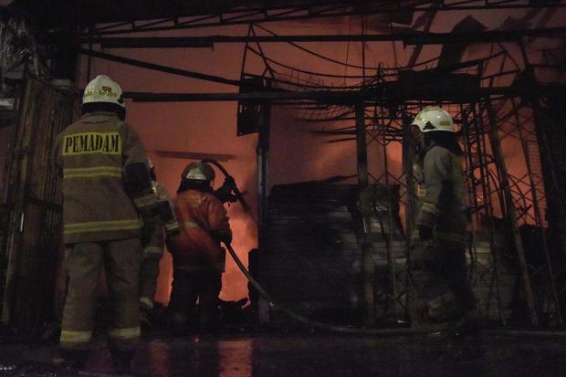 Petugas Dinas Penanggulangan Kebakaran dan Penyelamatan (Gulkarmat) memadamkan api yang membakar kios Pasar Taman Puring di Kebayoran Baru, Jakarta Selatan, Senin (28/7/2025). Sebanyak 118 personel Sudin Gulkarmat diturunkan untuk memadamkan api yang menghanguskan sekitar 500 kios pedagang.