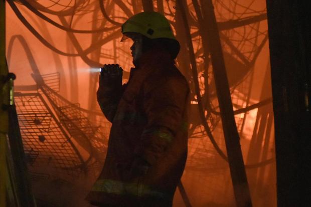 Petugas Dinas Penanggulangan Kebakaran dan Penyelamatan (Gulkarmat) memeriksa kios Pasar Taman Puring yang masih terbakar di Kebayoran Baru, Jakarta Selatan, Senin (28/7/2025). Sebanyak 118 personel Sudin Gulkarmat diturunkan untuk memadamkan api yang menghanguskan sekitar 500 kios pedagang.
