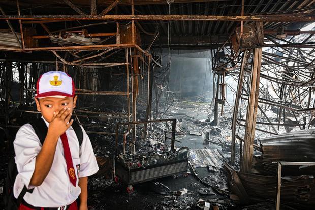 Seorang siswa melihat lokasi bekas kebakaran di Pasar Taman Puring, Kebayoran Baru, Jakarta, Selasa (29/7/2025). Sudin Gulkarmat Jakarta Selatan mencatat sebanyak 552 kios ludes terbakar dengan taksiran kerugian sekitar Rp30 miliar.