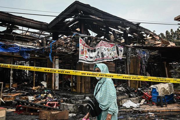 Warga melintas di lokasi bekas kebakaran di Pasar Taman Puring, Kebayoran Baru, Jakarta, Selasa (29/7/2025). Sudin Gulkarmat Jakarta Selatan mencatat sebanyak 552 kios ludes terbakar dengan taksiran kerugian sekitar Rp30 miliar.