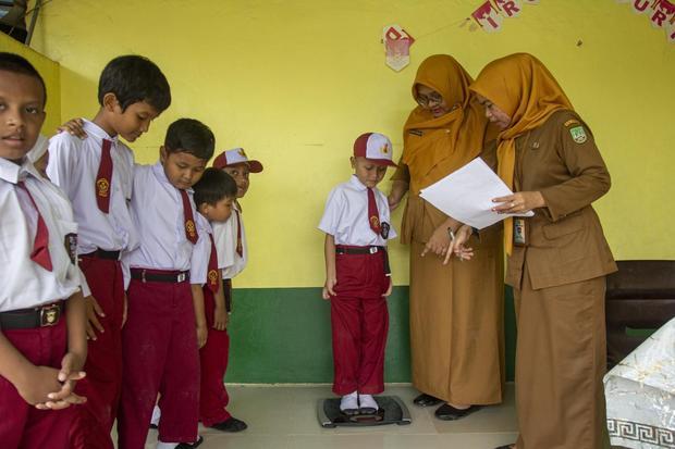 Petugas Puskesmas Botania Kota Batam menimbang berat badan siswa pada layanan Cek Kesehatan Gratis (CKG) di SD Nusa indah, Batam, Kepulauan Riau, Senin (4/8/2025). Program layanan CKG yang menargetkan sekitar 200 ribu siswa aktif jenjang SD hingga SMA sederajat se-Kota Batam tersebut sebagai langkah pencegahan masalah kesehatan sejak usia sekolah.