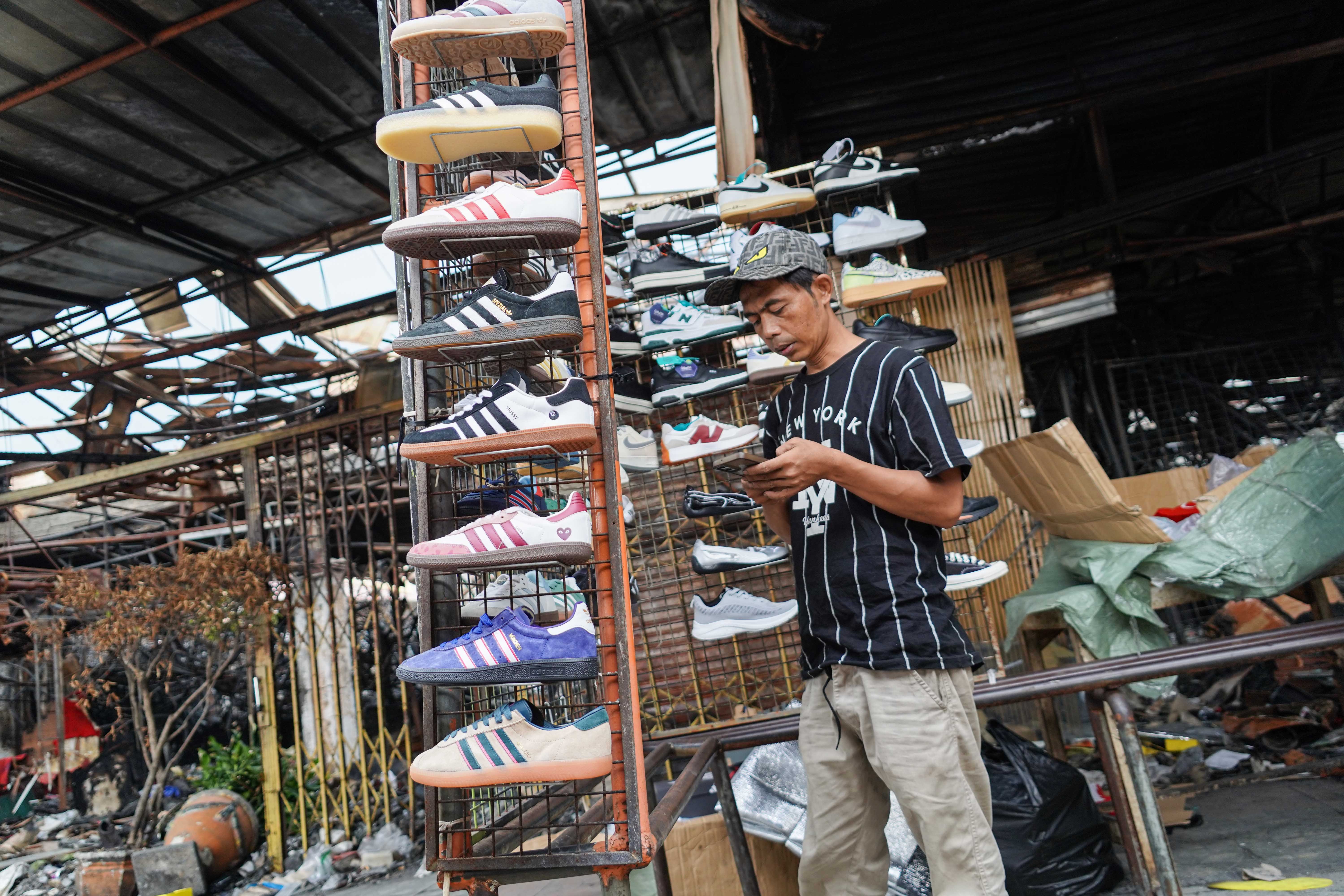 Pedagang menunggu pembeli di Pasar Taman Puring, Kebayoran Baru, Jakarta Selatan, Senin (4/8/2025). Sepekan pascakebakaran yang menghanguskan 552 kios pada Senin (28/7/2025) malam, sejumlah pedagang memanfaatkan trotoar di depan pasar untuk menjajakan barang dagangannya sambil menanti kejelasan pasar tersebut dibangun kembali.