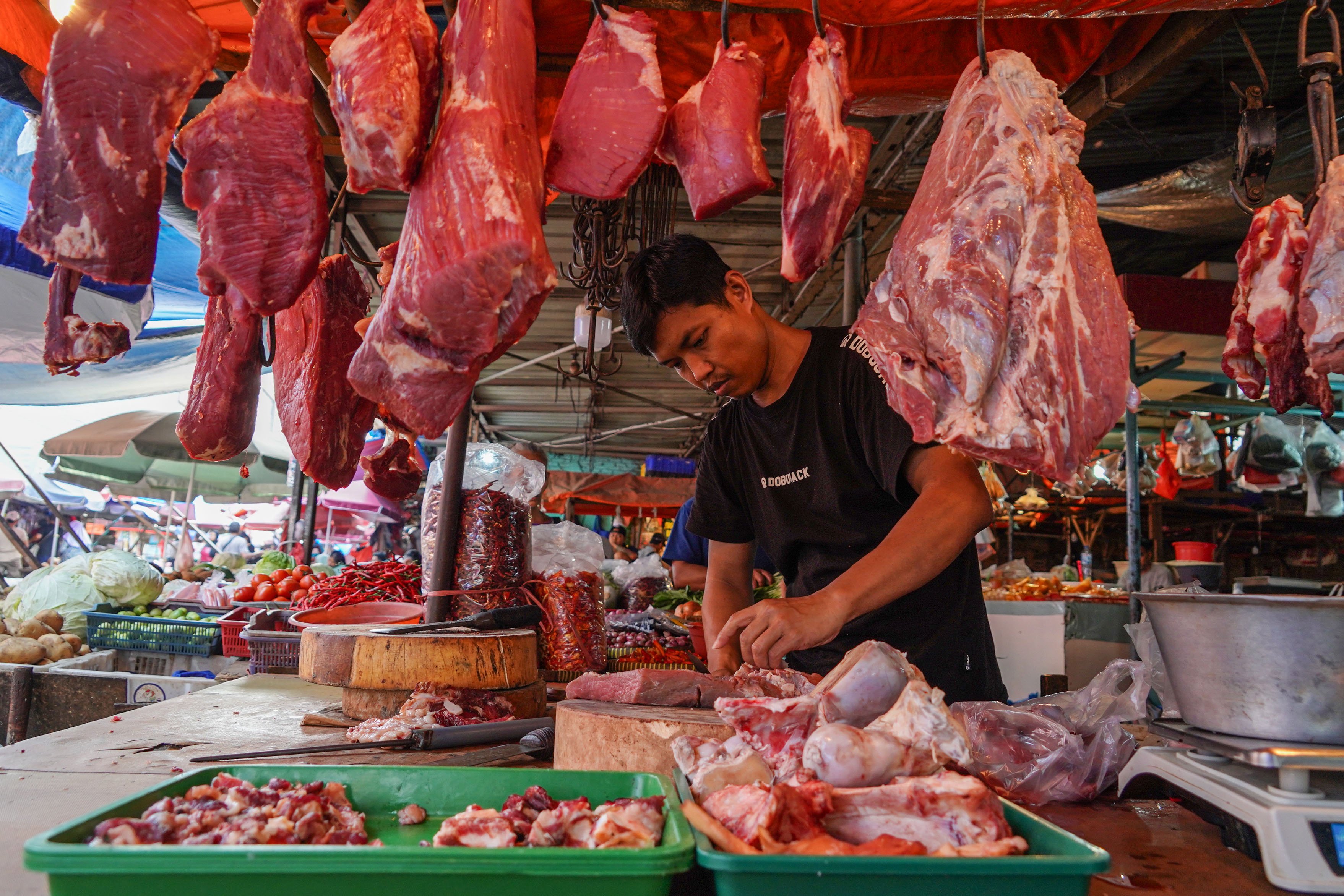 Pedagang memotong daging sapi yang dijual di Pasar Kebayoran Lama, Jakarta, Senin (6/8/2025). Badan Pusat Statistik (BPS) mencatat pertumbuhan ekonomi Indonesia pada kuartal II 2025 tumbuh sebesar 5,12% secara tahunan (year on year) yang didorong oleh kinerja positif di hampir seluruh lapangan usaha antara lain industri pengolahan, pertanian, perdagangan, konstruksi, dan pertambangan.