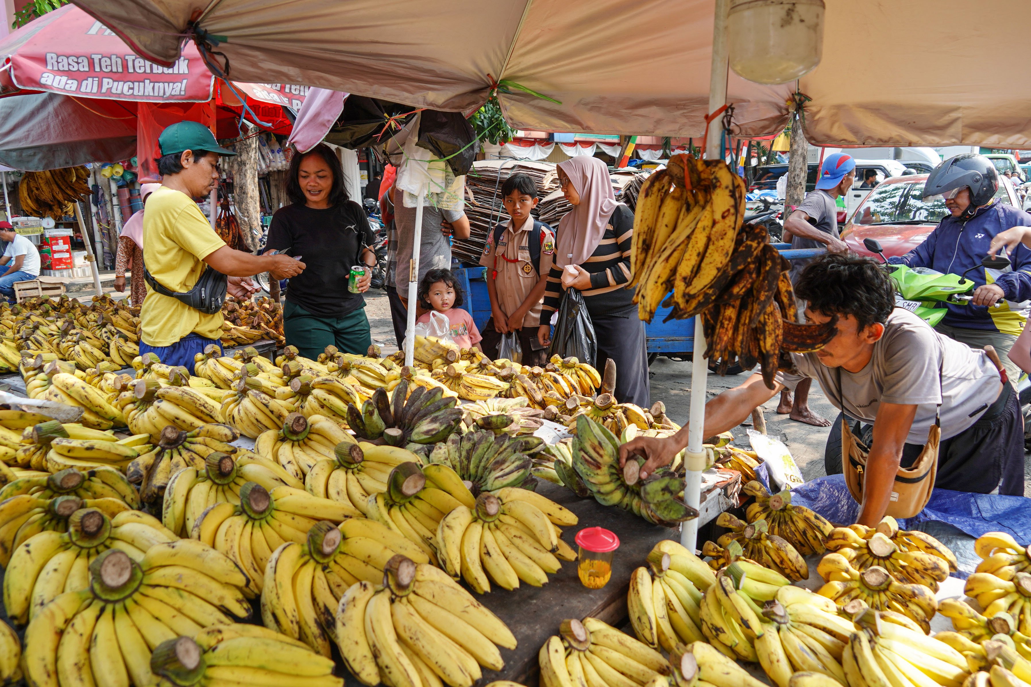 Pedagang melayani warga yang membeli pisang di Pasar Kebayoran Lama, Jakarta, Senin (6/8/2025). Badan Pusat Statistik (BPS) mencatat pertumbuhan ekonomi Indonesia pada kuartal II 2025 tumbuh sebesar 5,12% secara tahunan (year on year) yang didorong oleh kinerja positif di hampir seluruh lapangan usaha antara lain industri pengolahan, pertanian, perdagangan, konstruksi, dan pertambangan.