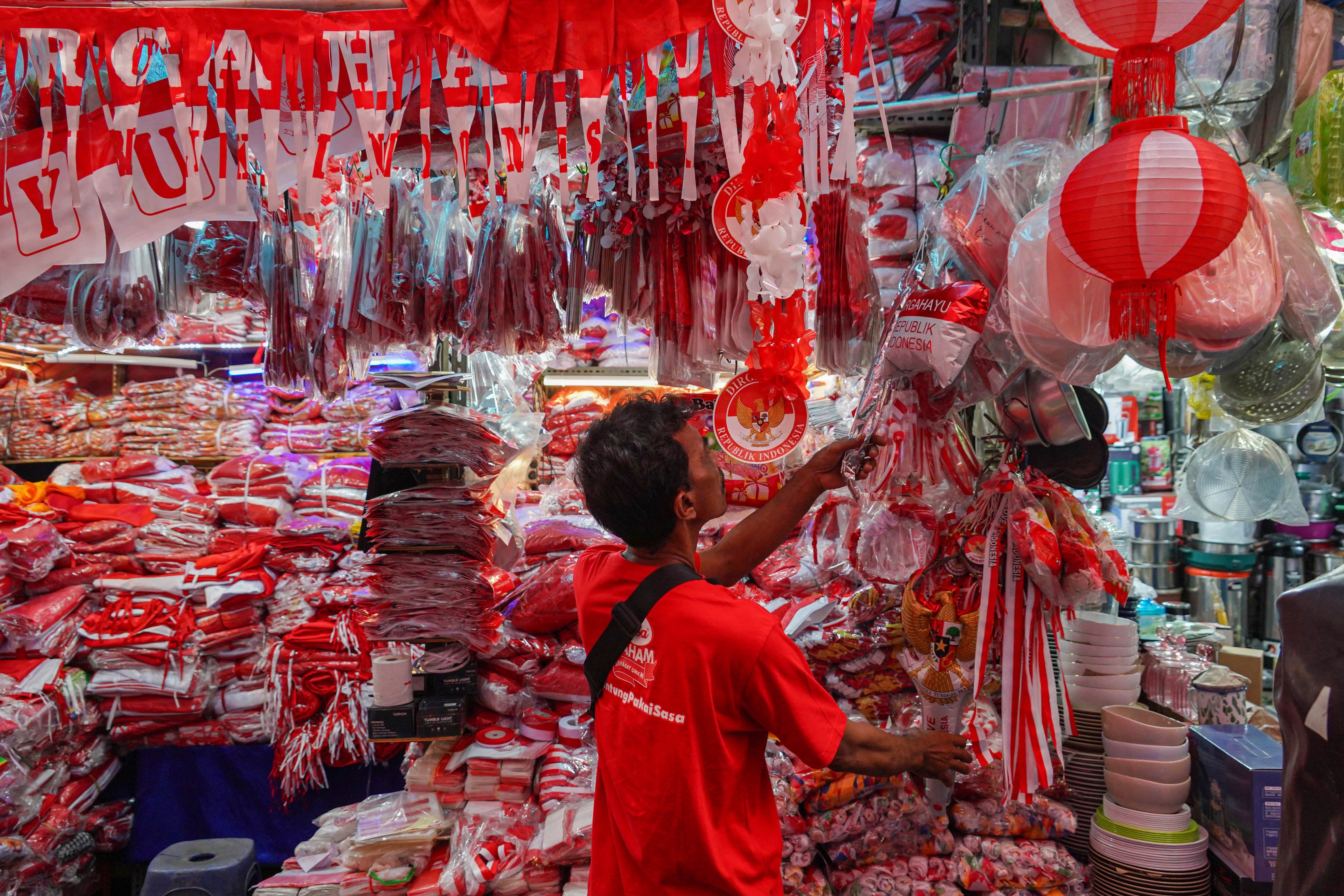 Warga melihat pernak pernik bernuansa merah putih yang dijual di Pasar Jatinegara, Jakarta Timur, Senin (11/8/2025). Hiasan bertemakan HUT ke-80 Kemerdekaan Republik Indonesia seperti stiker, balon, bendera dan umbul-umbul tersebut dijual dengan harga kisaran mulai dari Rp2.000 hingga jutaan rupiah tergantung jenis dan ukurannya.