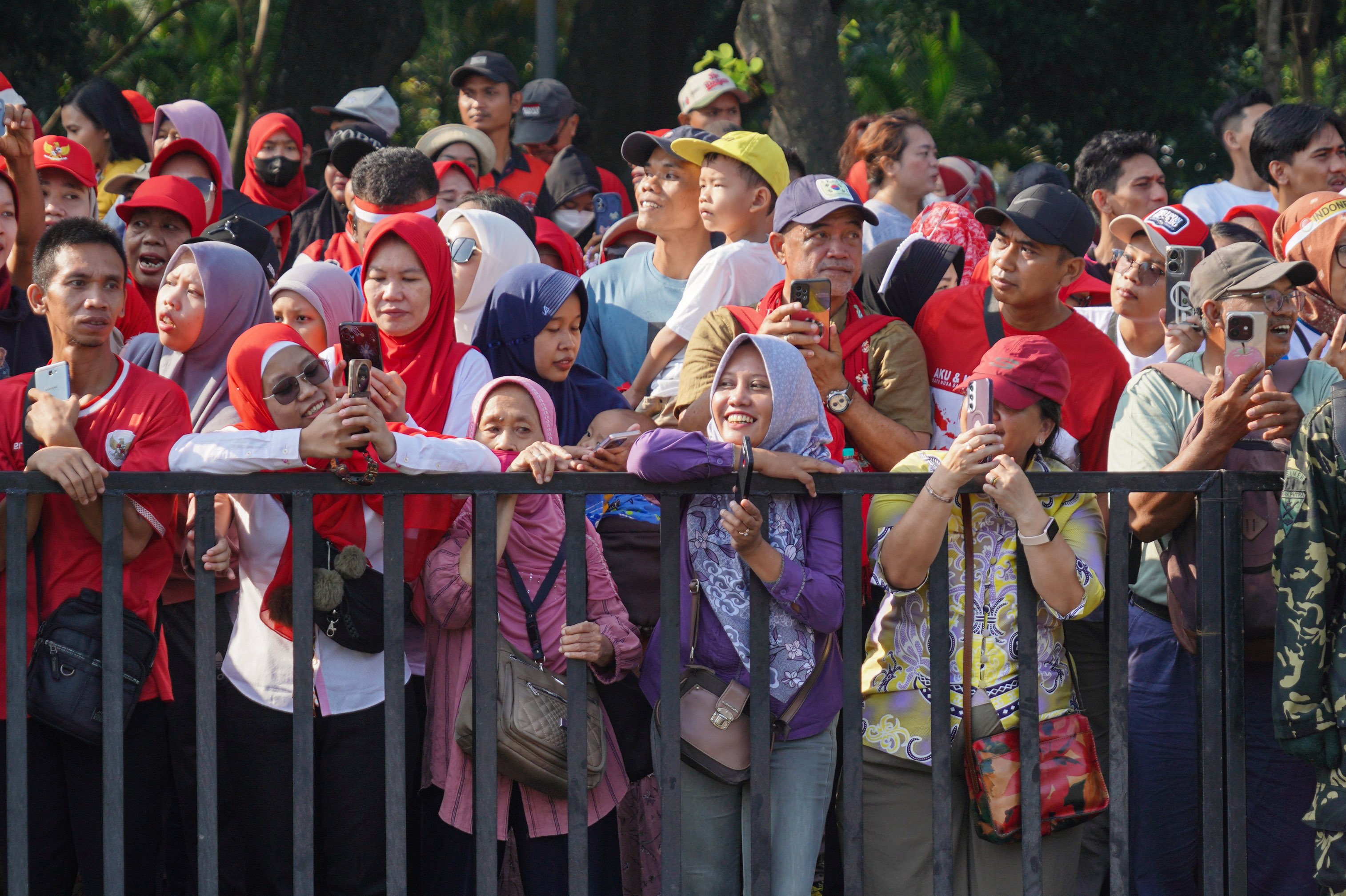 Sejumlah warga menyaksikan Kirab Bendera Pusaka Merah Putih di kawasan Monumen Nasional (Monas), Jakarta, Minggu (17/8/2025). Kirab Bendera Merah Putih dari Monas menuju Istana Merdeka tersebut dalam rangka Upacara Peringatan Detik-Detik Proklamasi Kemerdekaan ke-80 Republik Indonesia.