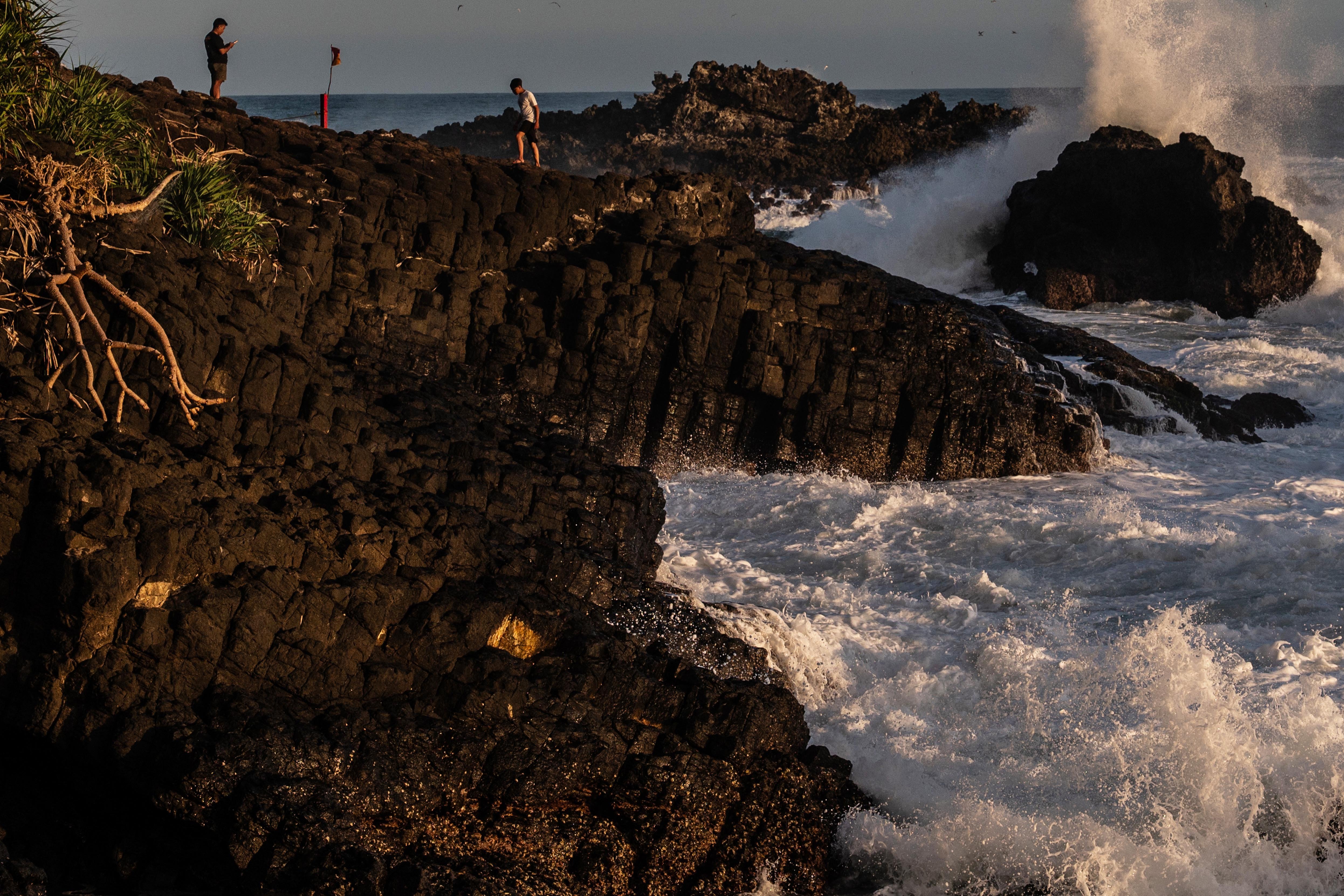 Wisatawan berjalan di bebatuan columnar joint (struktur basalt kolumnar) kawasan Geosite Pantai Menganti, Desa Karangduwur, Kecamatan Ayah, Kabupaten Kebumen, Jawa Tengah.