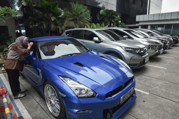 Petugas mengamati mobil milik Wakil Menteri Ketenagakerjaan Immanuel Ebenezer yang disita KPK di Gedung Merah Putih KPK, Jakarta Selatan, Kamis (21/8/2025). Komisi Pemberantasan Korupsi (KPK) menyita 22 kendaraan milik Immanuel Ebenezer terdiri dari 15 mobil dan tujuh sepeda motor terkait operasi tangkap tangan (OTT).