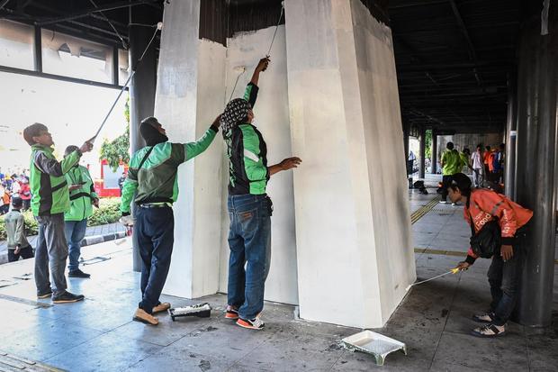 Sejumlah pengemudi ojek daring mengecat Halte Senen Sentral di Jakarta, Senin (1/9/2025). Pemprov DKI Jakarta menggelar aksi Gotong Royong Gerak Cepat Jaga Jakarta bersama sejumlah pelajar, pengemudi ojek daring, dan petugas gabungan untuk membersihkan sejumlah fasilitas umum seperti halte Transjakarta yang terbakar dan diharapkan dapat kembali membuka layanan pada pekan depan.