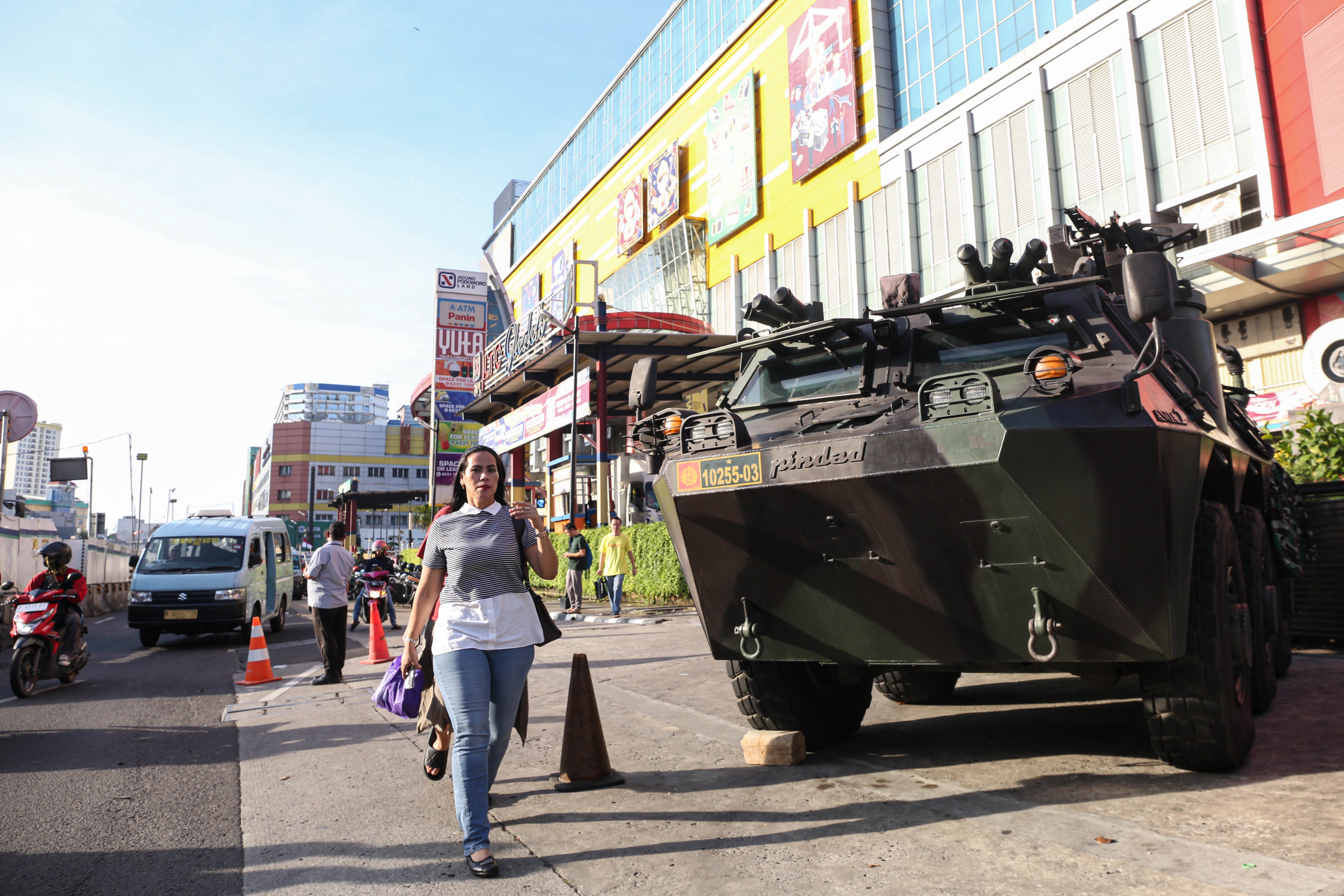 Warga dan pengendara melintas di dekat kendaraan taktis TNI yang disiagakan di depan LTC Glodok, Jalan Hayam Wuruk, Jakarta, Selasa (2/9/2025). Penjagaan tersebut dilakukan untuk memberikan situasi aman kepada masyarakat setelah sebelumnya dalam beberapa hari terakhir terjadi aksi unjuk rasa yang berujung kericuhan di sejumlah titik wilayah Jakarta.