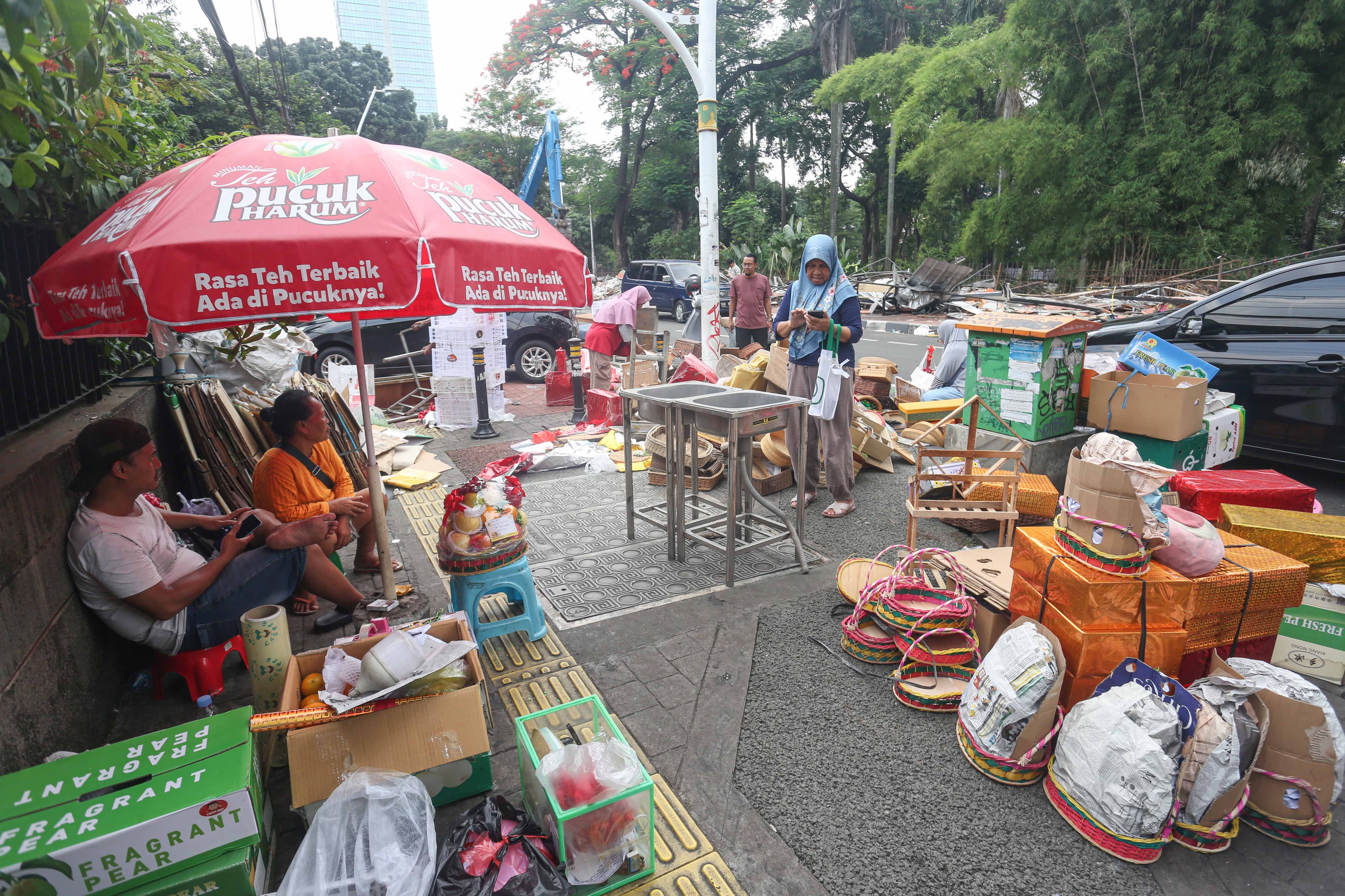 Pedagang berada di dekat barang dagangannya saat pembongkaran kios di Pasar Barito, Jakarta, Senin (27/10/2025). Pemerintah Kota Jakarta Selatan merelokasi pedagang Pasar Barito ke Sentra Fauna dan Kuliner Lenteng Agung untuk membangun Taman Bendera Pusaka.