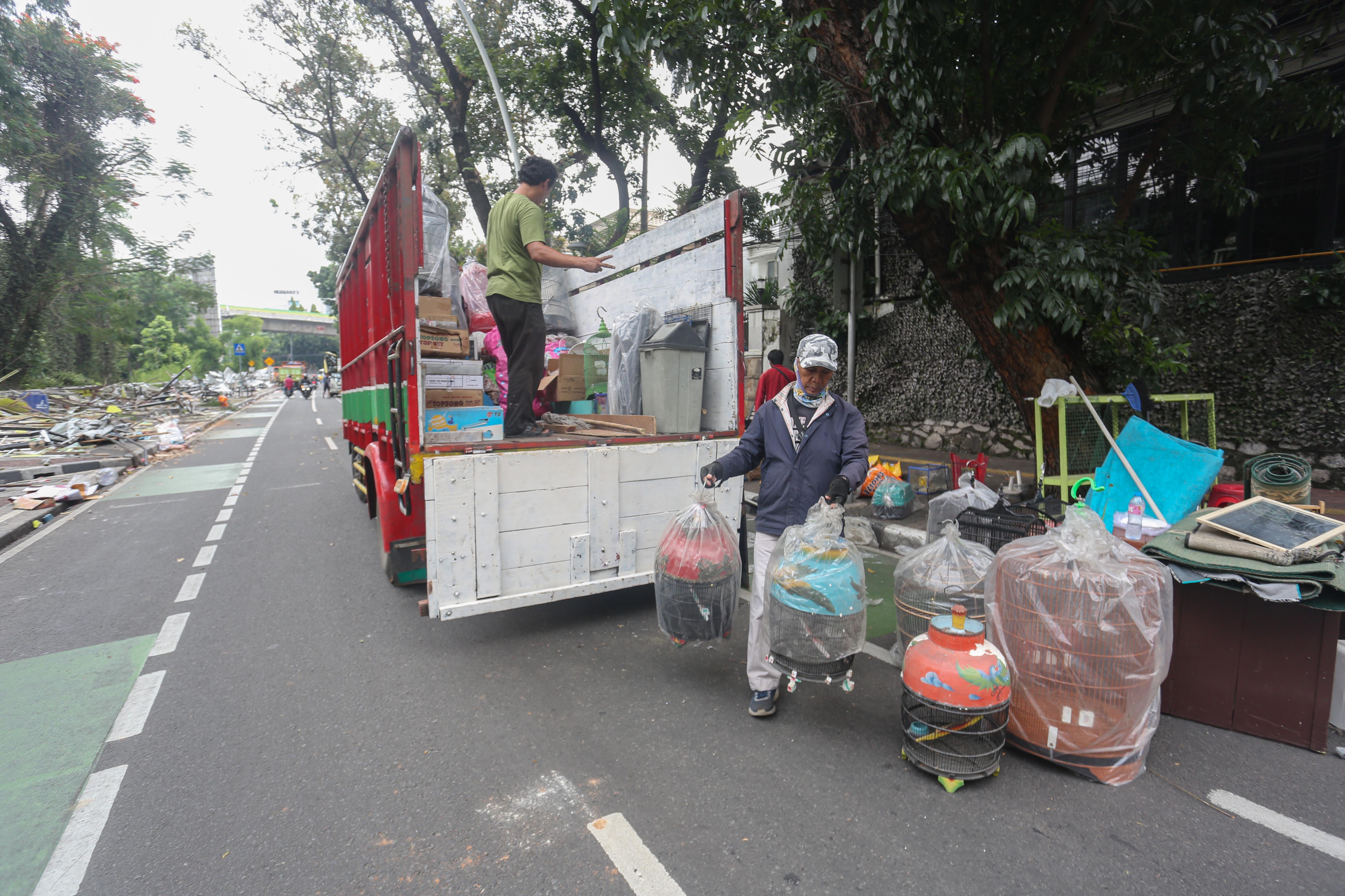 Pedagang mengangkut kandang burung saat pembongkaran kios di Pasar Barito, Jakarta, Senin (27/10/2025). Pemerintah Kota Jakarta Selatan merelokasi pedagang Pasar Barito ke Sentra Fauna dan Kuliner Lenteng Agung untuk membangun Taman Bendera Pusaka.