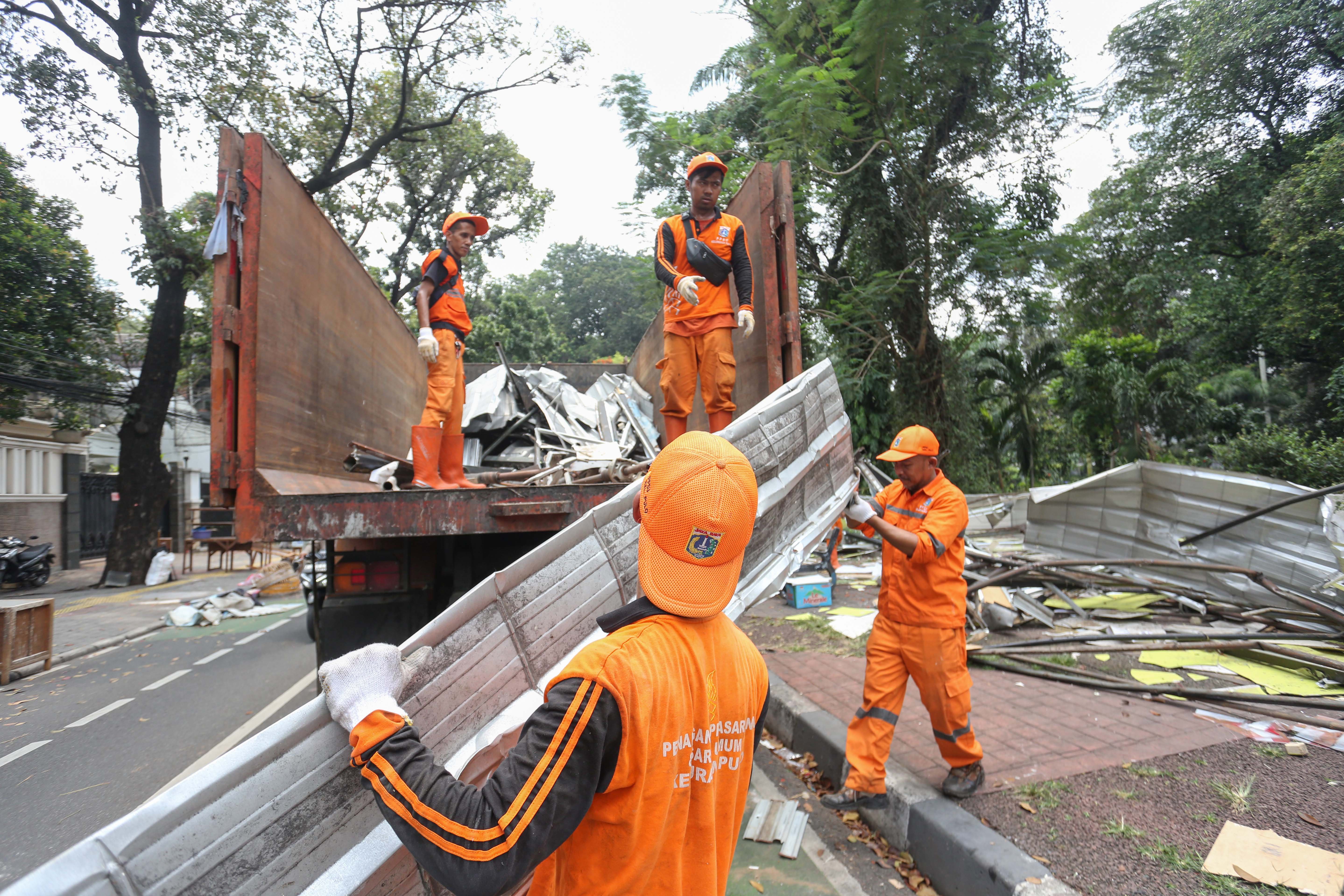 Petugas Penanganan Prasarana dan Sarana Umum (PPSU) mengangkut puing-puing kios pedagang usai pembongkaran di Pasar Barito, Jakarta, Senin (27/10/2025). Pemerintah Kota Jakarta Selatan merelokasi pedagang Pasar Barito ke Sentra Fauna dan Kuliner Lenteng Agung untuk membangun Taman Bendera Pusaka.