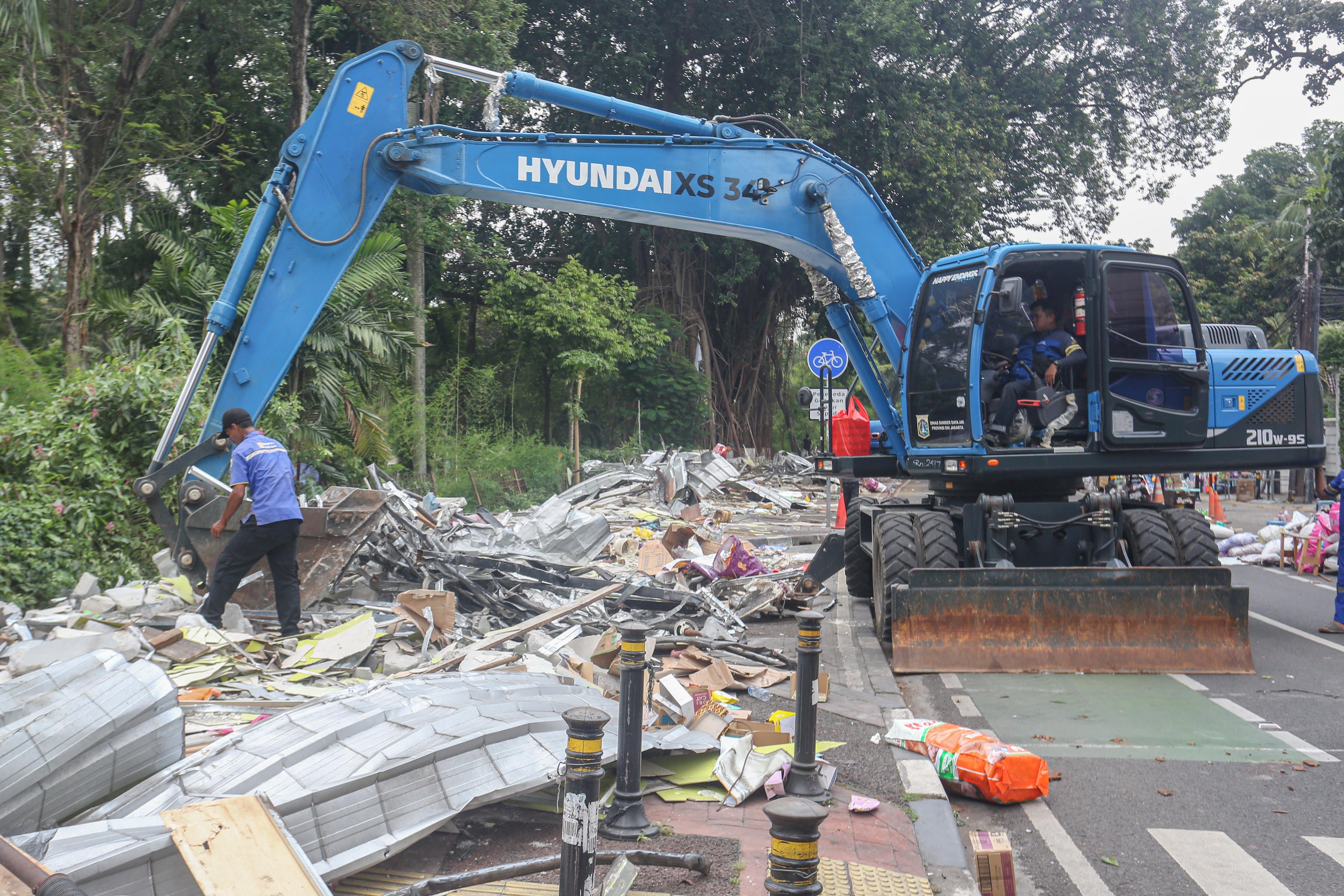 Petugas menggunakan ekskavator saat membongkar kios pedagang di Pasar Barito, Jakarta, Senin (27/10/2025). Pemerintah Kota Jakarta Selatan merelokasi pedagang Pasar Barito ke Sentra Fauna dan Kuliner Lenteng Agung untuk membangun Taman Bendera Pusaka.