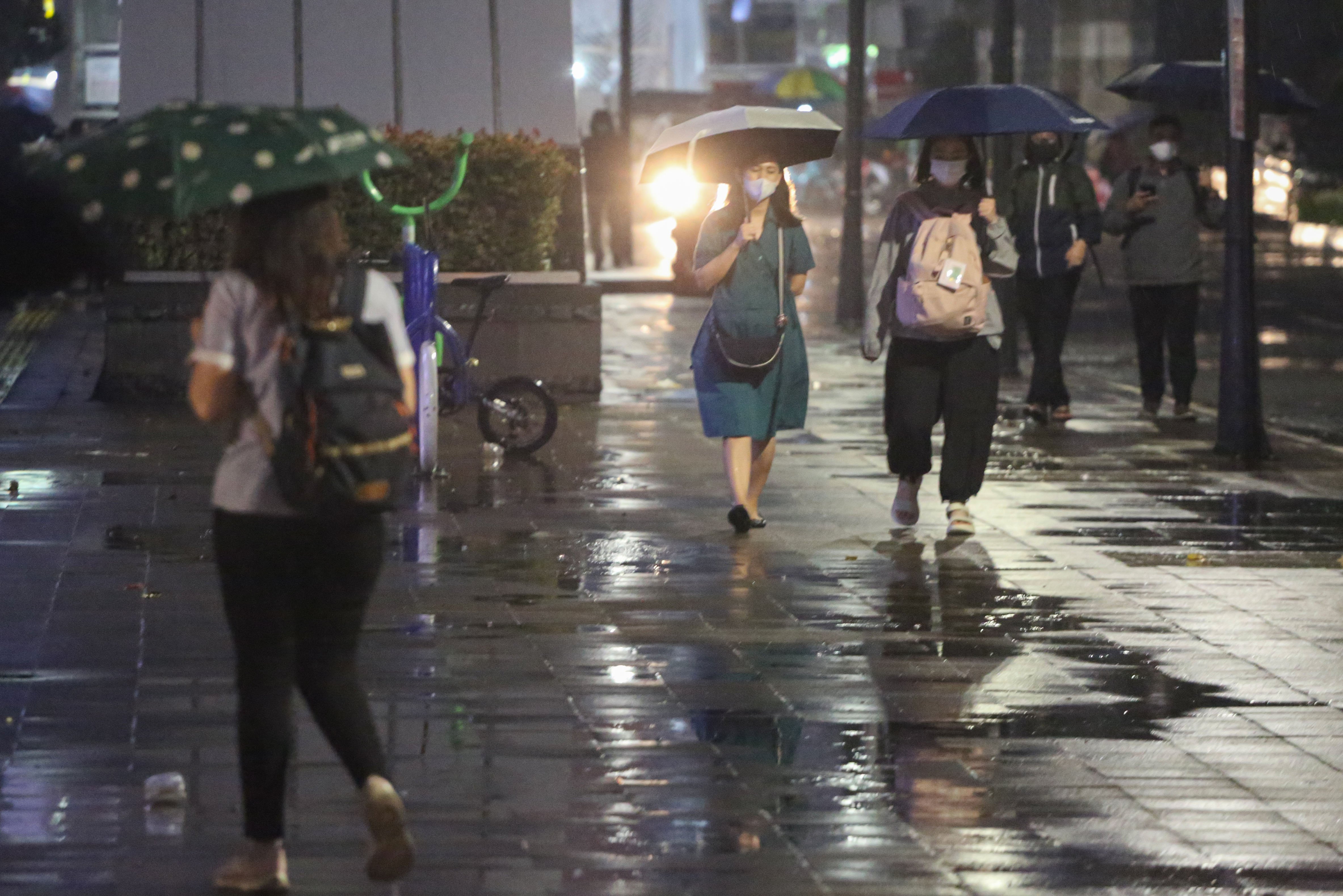 Warga memakai payung saat hujan di kawasan Dukuh Atas, Jakarta, Rabu (29/10/2025). Menteri Kesehatan, Budi Gunadi Sadikin menghimbau kepada masyarakat untuk mengenakan masker dan mengurangi aktivitas setelah hujan menyusul temuan Badan Riset dan Inovasi Nasional (BRIN) yang mengungkap air hujan di Jakarta mengandung mikroplastik.