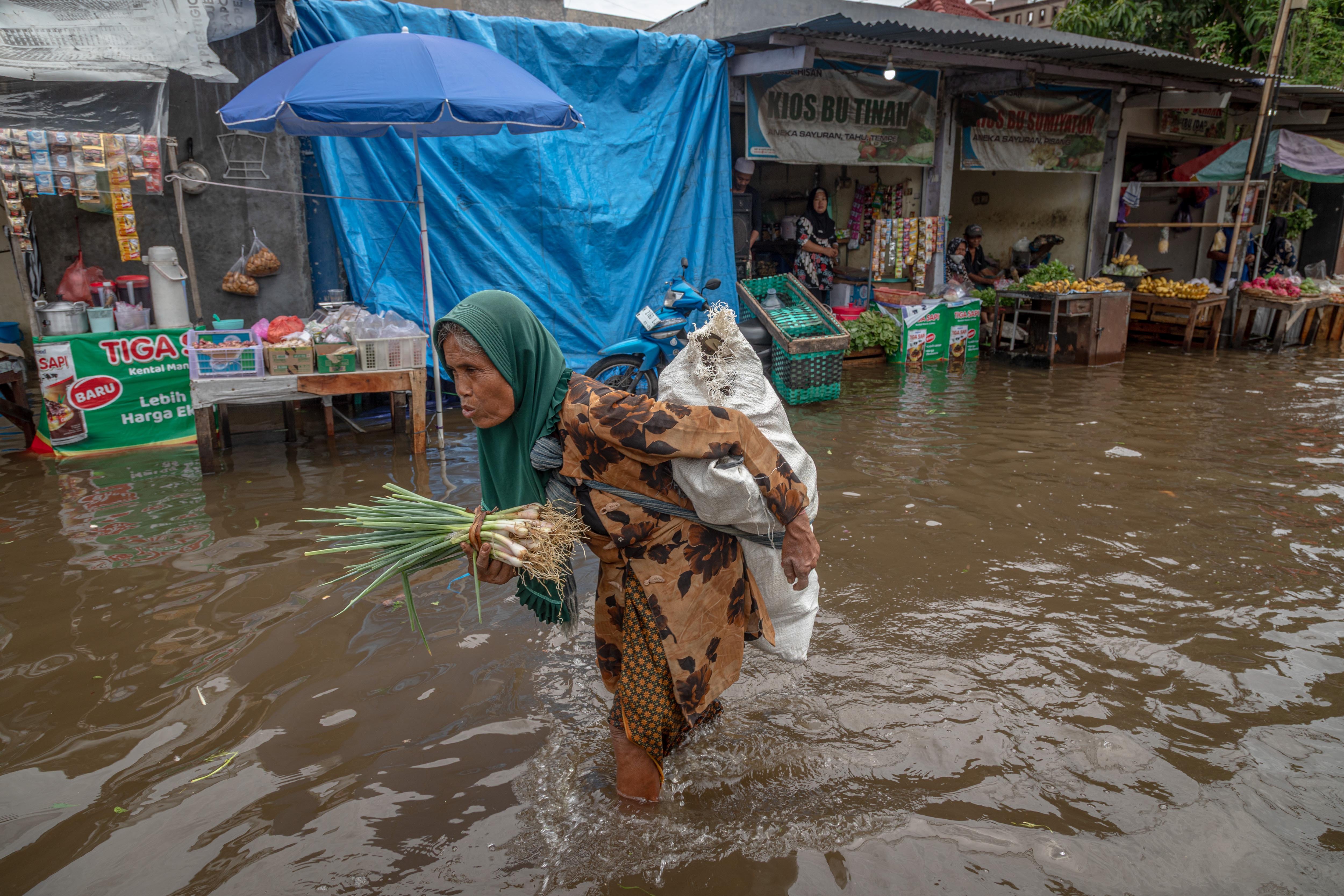 Pedagang berjalan pulang karena kondisi pasar sepi dampak banjir di kawasan Pasar Tradisional Genuk, Kota Semarang, Jawa Tengah, Kamis (23/10/2025). Hari kedua banjir yang melanda Kota Semarang dampak dari anomali cuaca dengan intensitas hujan tinggi pada Selasa (21/10) hingga Kamis (23/10) membuat pasar tergenang banjir setinggi sekitar 10-30 sentimeter sehingga mengganggu perekonomian warga. 