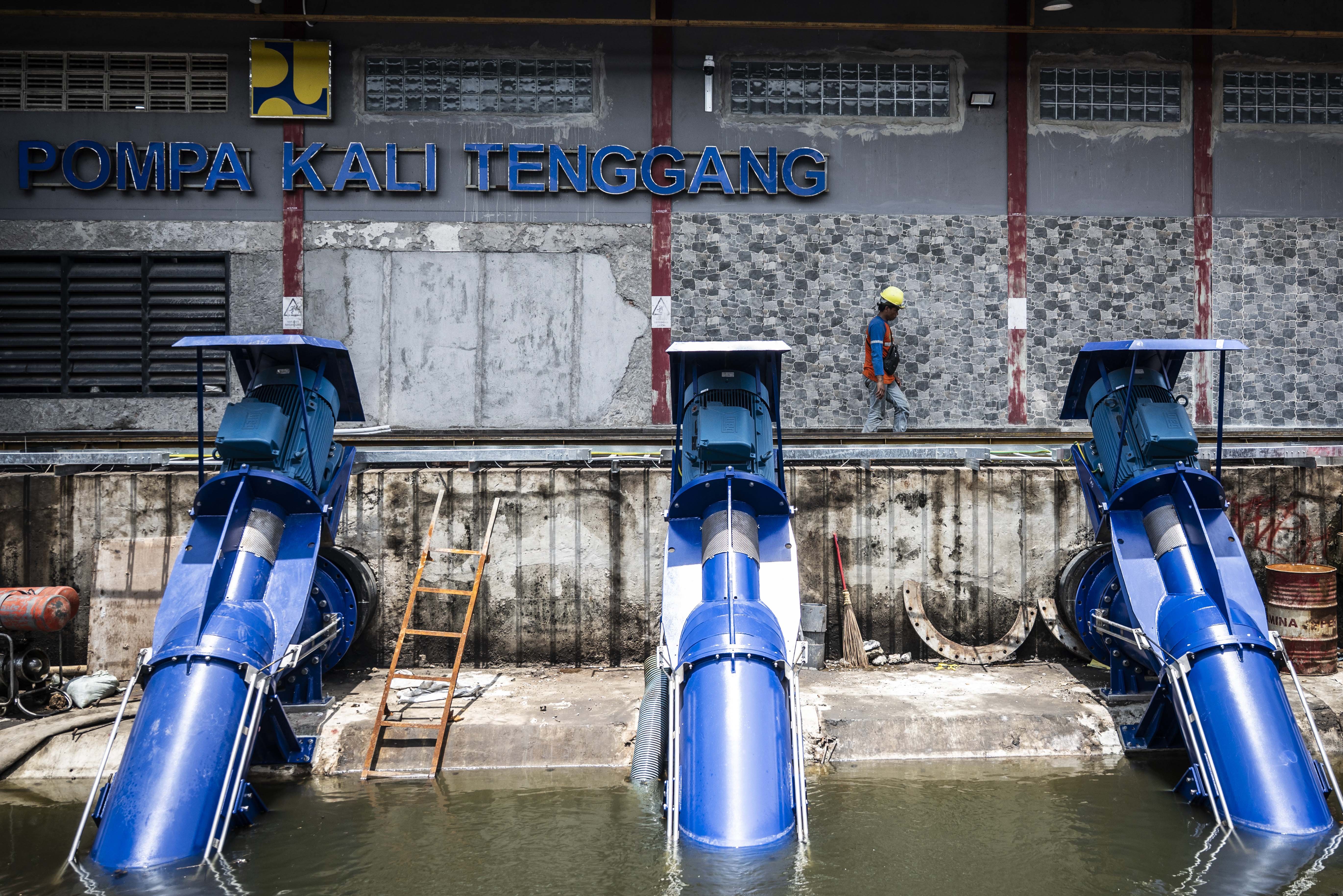 Petugas Balai Besar Wilayah Sungai (BBWS) Pemali Juana berjalan di Rumah Pompa Kali Tenggang, Semarang, Jawa Tengah, Jumat (24/10/2025). BBWS Pemali Juana Kementerian Pekerjaan Umum mengoperasikan Rumah Pompa Kali Tenggang dengan kapasitas total 2.000 liter per detik serta menambah lima unit pompa mobile tambahan dengan kapasitas sedot 500 liter air per detik untuk mengatasi banjir yang melanda wilayah Pantura Semarang.