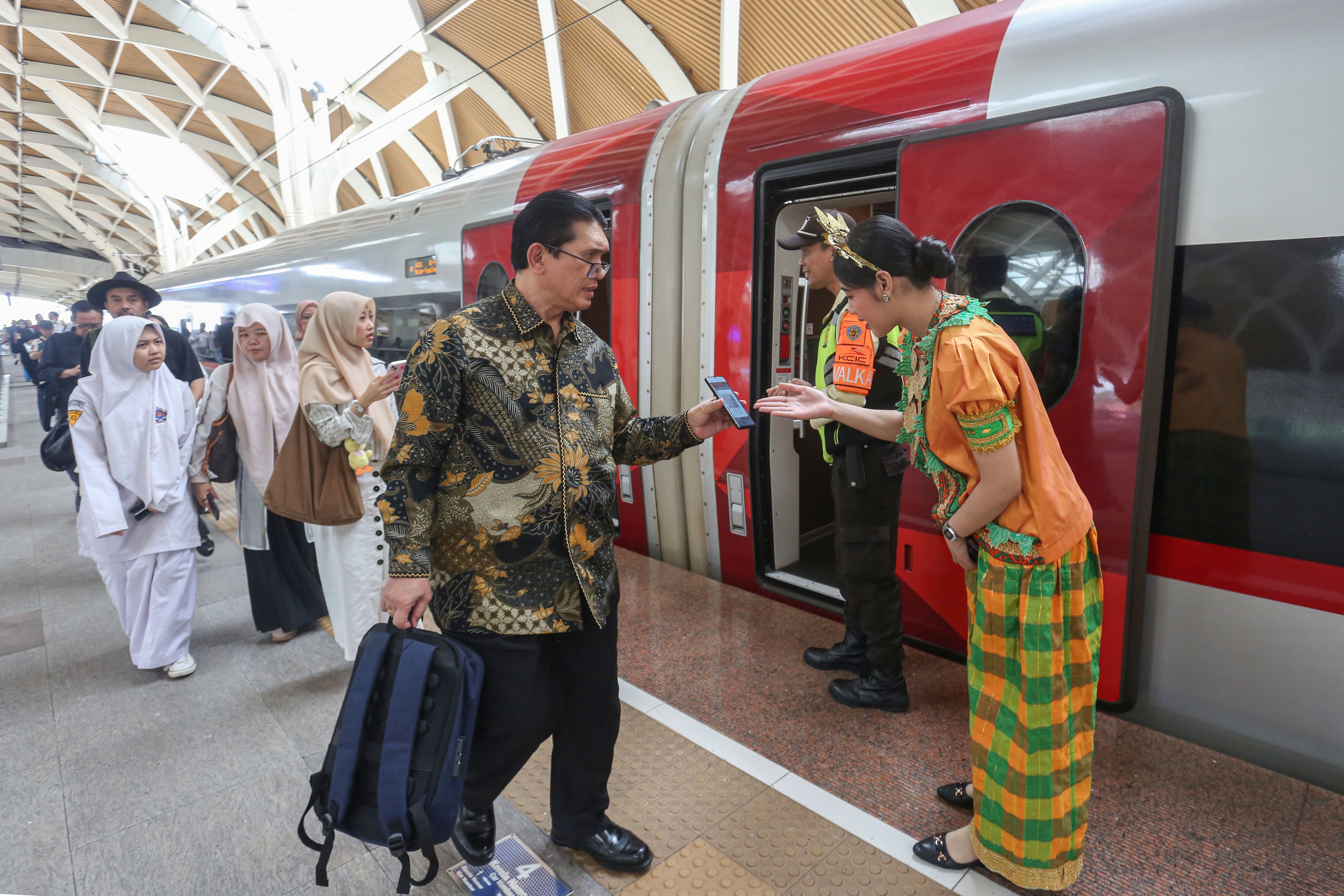 Petugas mengarahkan penumpang yang akan menaiki Kereta Cepat Woosh di Stasiun Woosh Halim, Jakarta, Senin (10/11/2025). Komisi Pemberantasan Korupsi (KPK) tetap melanjutkan penyelidikan atas dugaan tindak pidana korupsi proyek kereta cepat Jakarta-Bandung atau Whoosh, walaupun Presiden Prabowo Subianto menyatakan akan bertanggung jawab atas kerugian proyek itu.