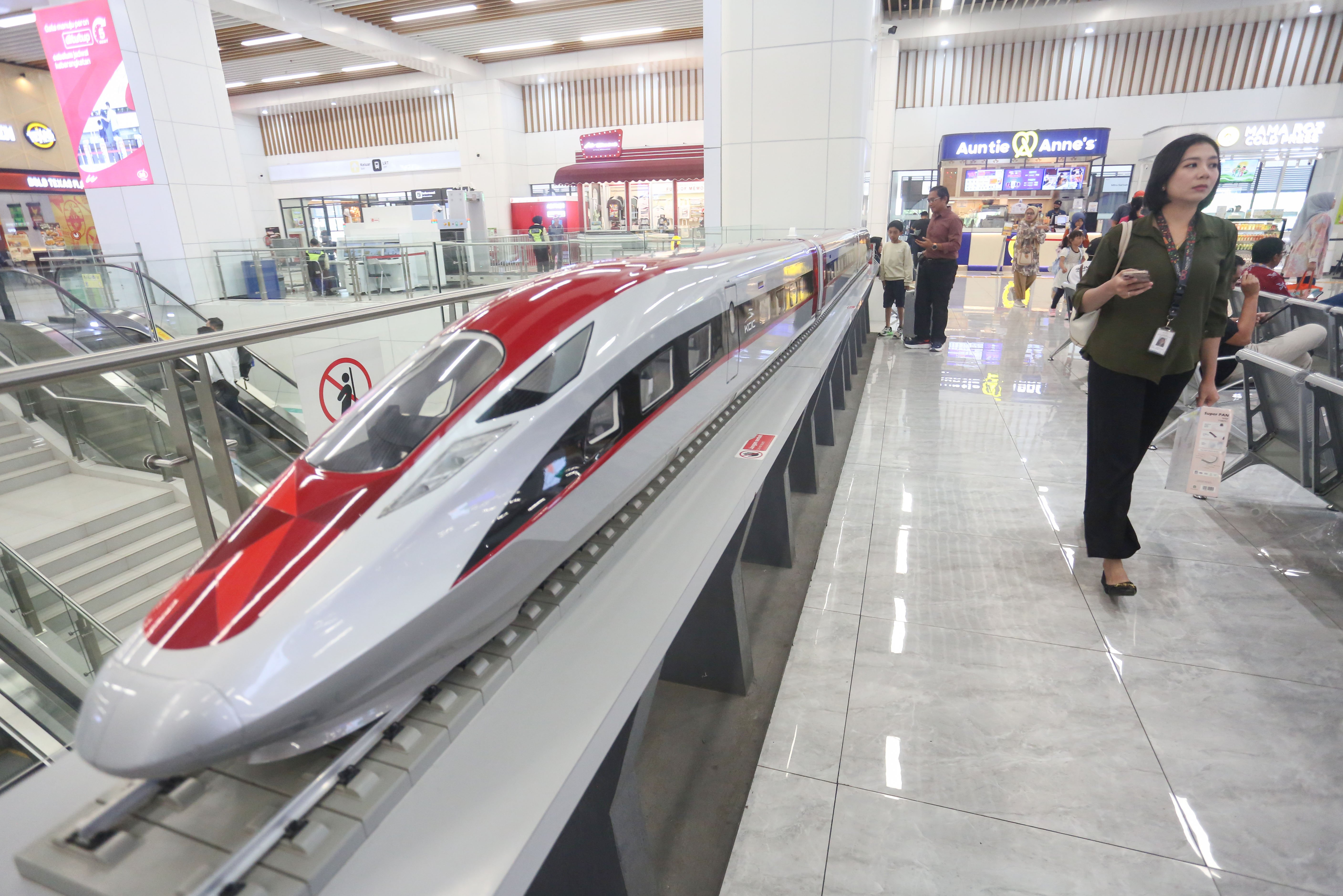 Penumpang berjalan di dekat miniatur Kereta Cepat Woosh di Stasiun Woosh Halim, Senin (10/11/2025). Komisi Pemberantasan Korupsi (KPK) tetap melanjutkan penyelidikan atas dugaan tindak pidana korupsi proyek kereta cepat Jakarta-Bandung atau Whoosh, walaupun Presiden Prabowo Subianto menyatakan akan bertanggung jawab atas kerugian proyek itu.