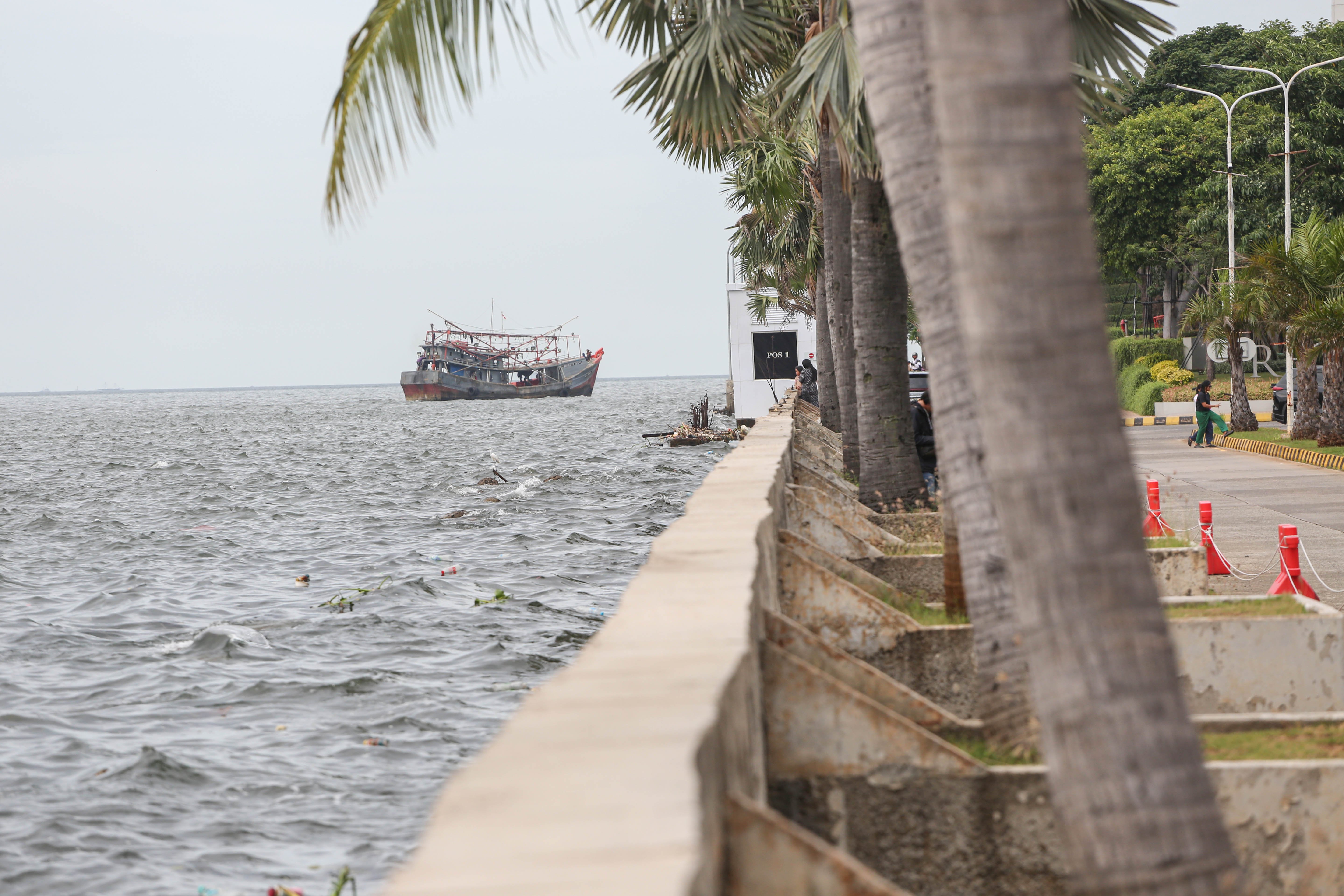 Kondisi air laut yang lebih tinggi daratan di kawasan Pantai Mutiara, Penjaringan, Jakarta Utara, Rabu (26/11/2025). Fenomena pasang maksimum air laut bersamaan dengan fase bulan baru dan turunnya permukaan tanah di Jakarta setiap tahunnya membuat air laut berada di posisi yang lebih tinggi dari jalan di kawasan tersebut.