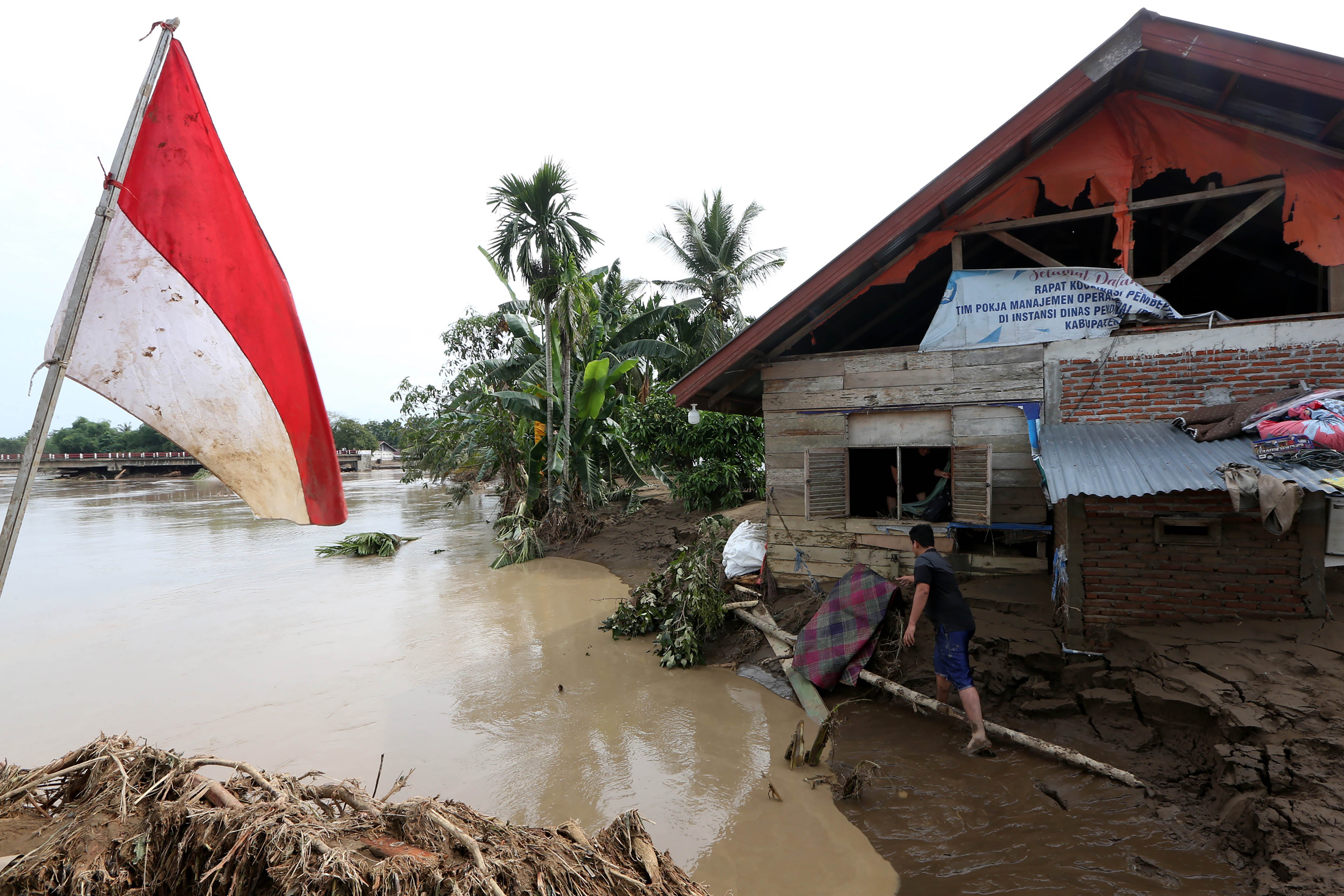 Warga menyelamatkan barang dari rumah yang tertimbun lumpur dan nyaris ambruk tergerus air sungai pascabencana banjir luapan sungai Meureudu di Desa Meunasah Krueng, kabupaten Pidie Jaya, Aceh, Jumat (28/11/2025). Bencana banjir yang terjadi sejak 25 November di kabupaten Pidie dan Pidie Jaya mengakibatkan ribuan rumah tergenang dan tertimbun lumpur hingga mencapai tiga meter lebih dan pada hari keempat warga mulai membersihkan rumah serta mengambil barang-barang yang masih dapat digunakan. 