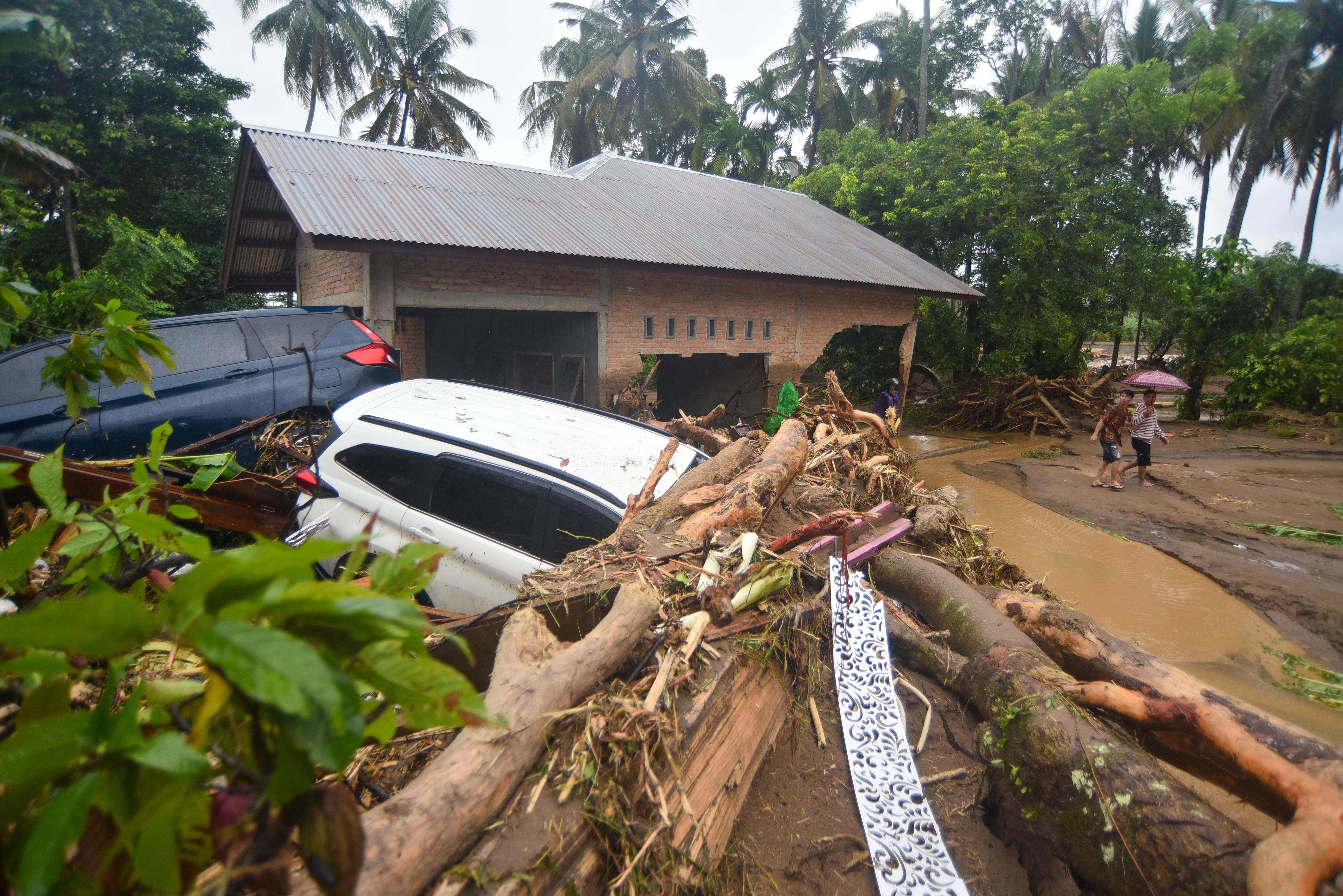 Warga melihat dua unit mobil yang terseret banjir bandang di Lubuk Minturun, Padang, Sumatera Barat, Kamis (27/11/2025). BPBD Padang mencatat, sebanyak lima orang tewas akibat banjir bandang di Sungai Lubuk Minturun itu, sementara sejumlah rumah dilaporkan hanyut dan sejumlah kendaraan rusak terseret banjir. 