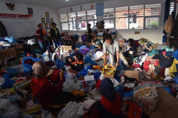 Sejumlah relawan merapikan bantuan pakaian bekas bagi korban banjir bandang di Batu Busuk, Padang, Sumatera Barat, Selasa (2/12/2025). Bantuan pakaian sangat dibutuhkan bagi korban banjir bandang di Padang, karena sebagian besar pakaian mereka terendam lumpur dan hanyut.