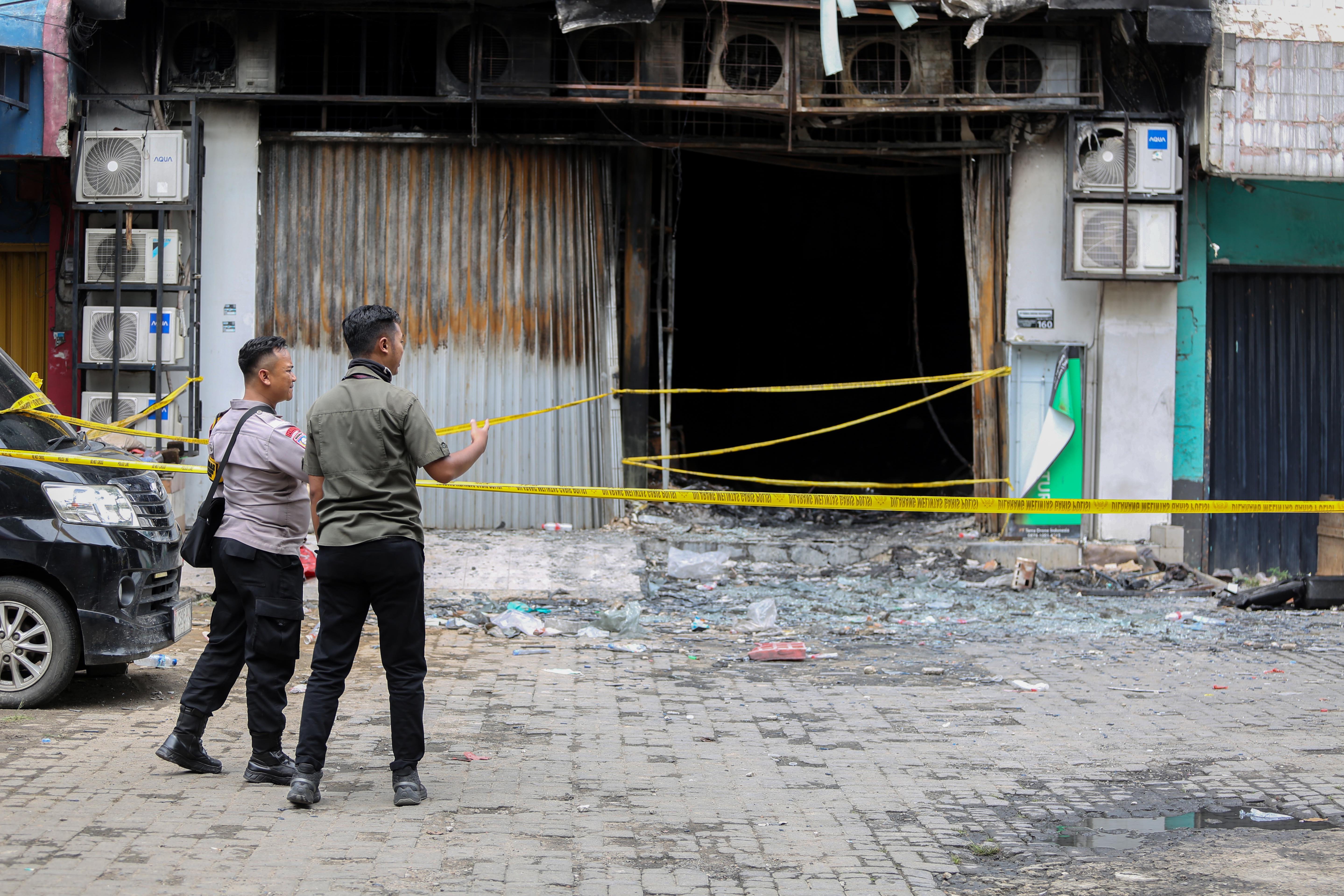 Petugas kepolisian berjaga di sekitar ruko PT Terra Drone Indonesia usai terbakar di Jalan Letnan Jenderal Suprapto, Cempaka Baru, Kemayoran, Jakarta Pusat, Rabu (10/12/2025). Kebakaran yang menghanguskan roku tujuh lantai yang terjadi pada Selasa (9/12) itu menewaskan 22 orang dengan 15 diantaranya perempuan dan tujuh orang lainnya laki-laki.
