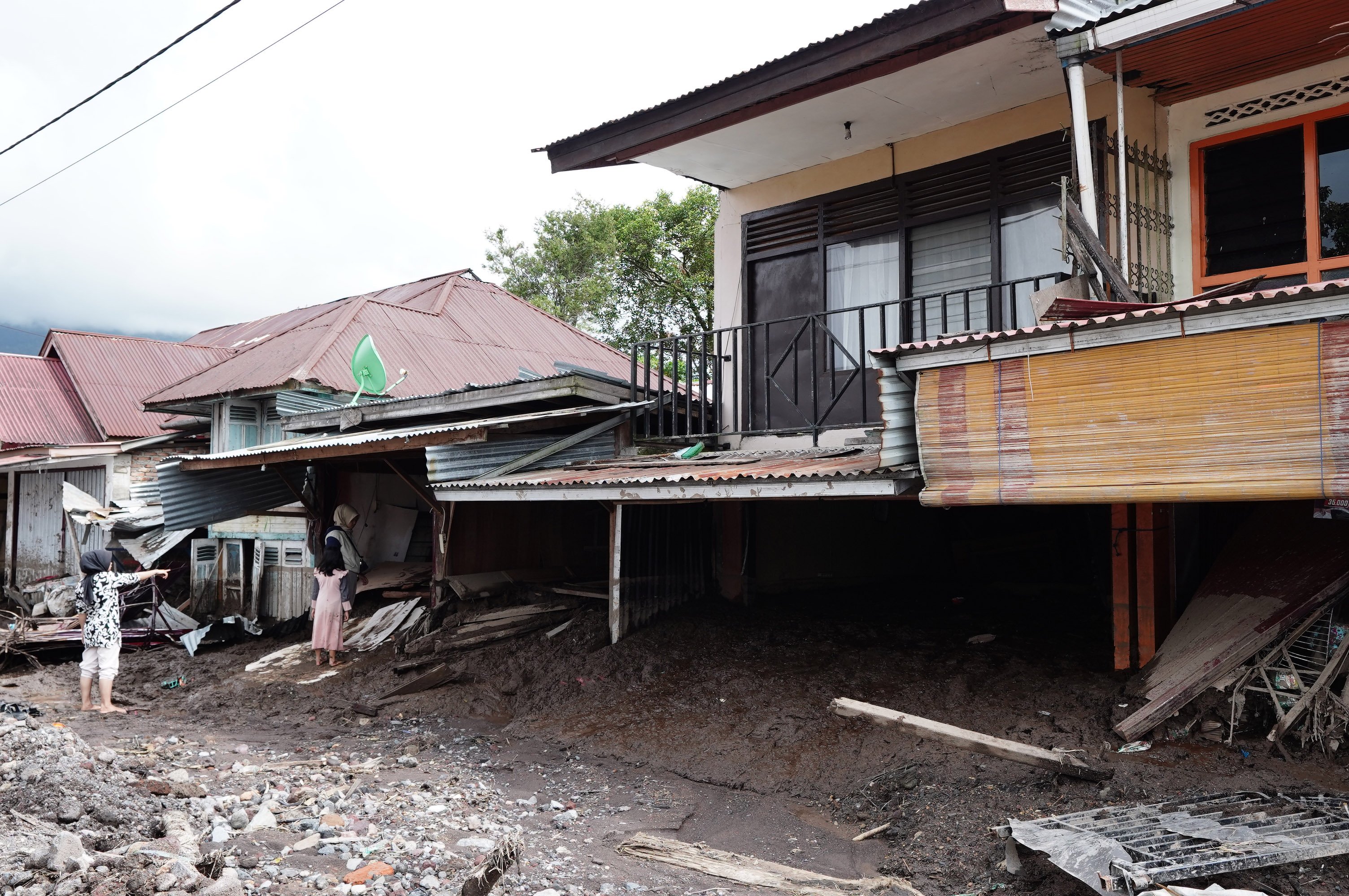 Warga melihat kondisi rumahnya yang rusak akibat diterjang banjir bandang dan tanah longsor di Kecamatan Malalak, Kabupaten Agam, Sumatera Barat, Minggu (7/12/2025). Sebanyak tiga dusun atau jorong di wilayah tersebut masih terisolir karena terputusnya akses jalan sehingga membuat distribusi logistik terhambat.