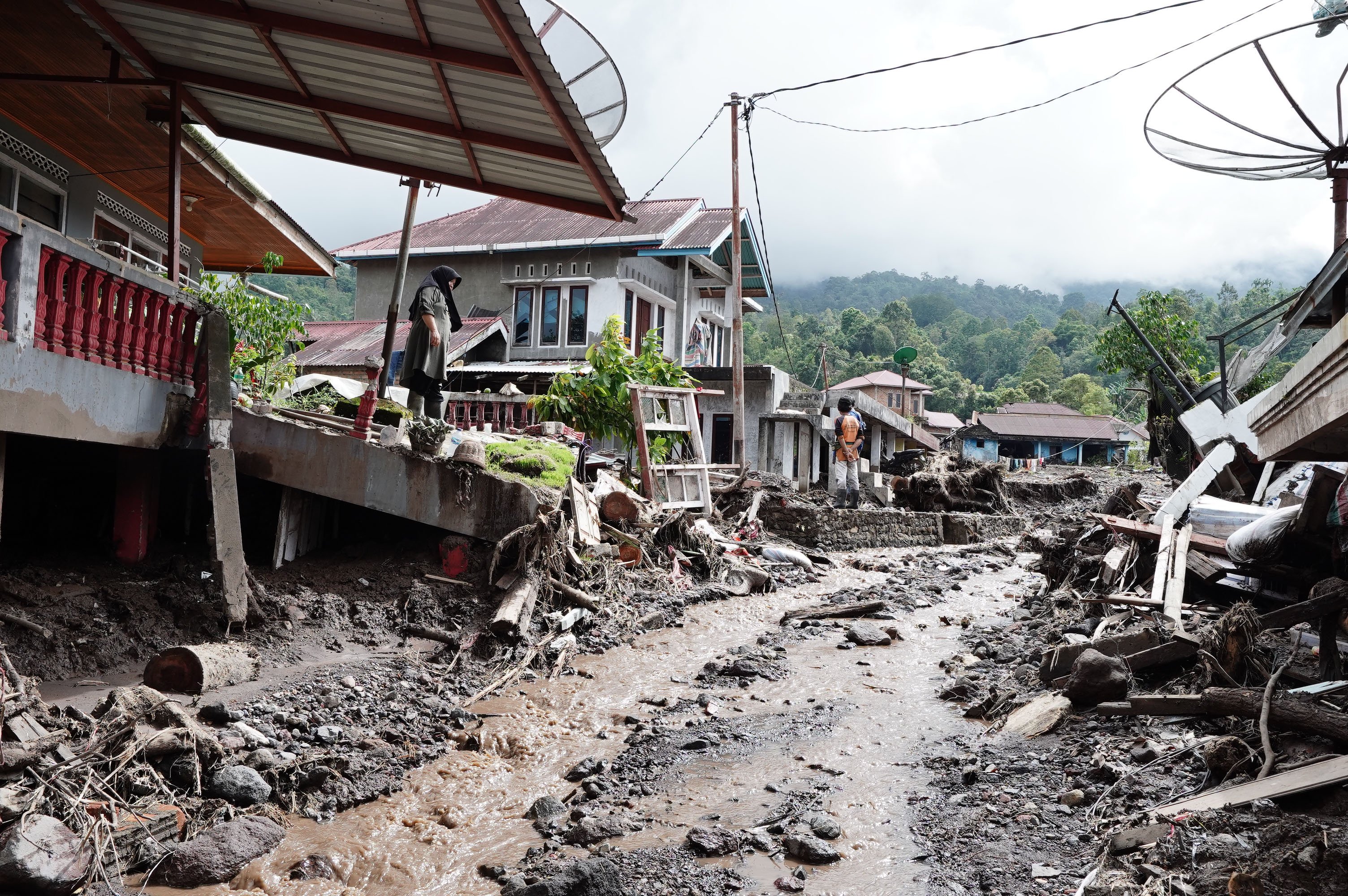 Warga melihat kondisi rumahnya yang rusak akibat diterjang banjir bandang dan tanah longsor di Kecamatan Malalak, Kabupaten Agam, Sumatera Barat, Minggu (7/12/2025). Sebanyak tiga dusun atau jorong di wilayah tersebut masih terisolir karena terputusnya akses jalan sehingga membuat distribusi logistik terhambat.