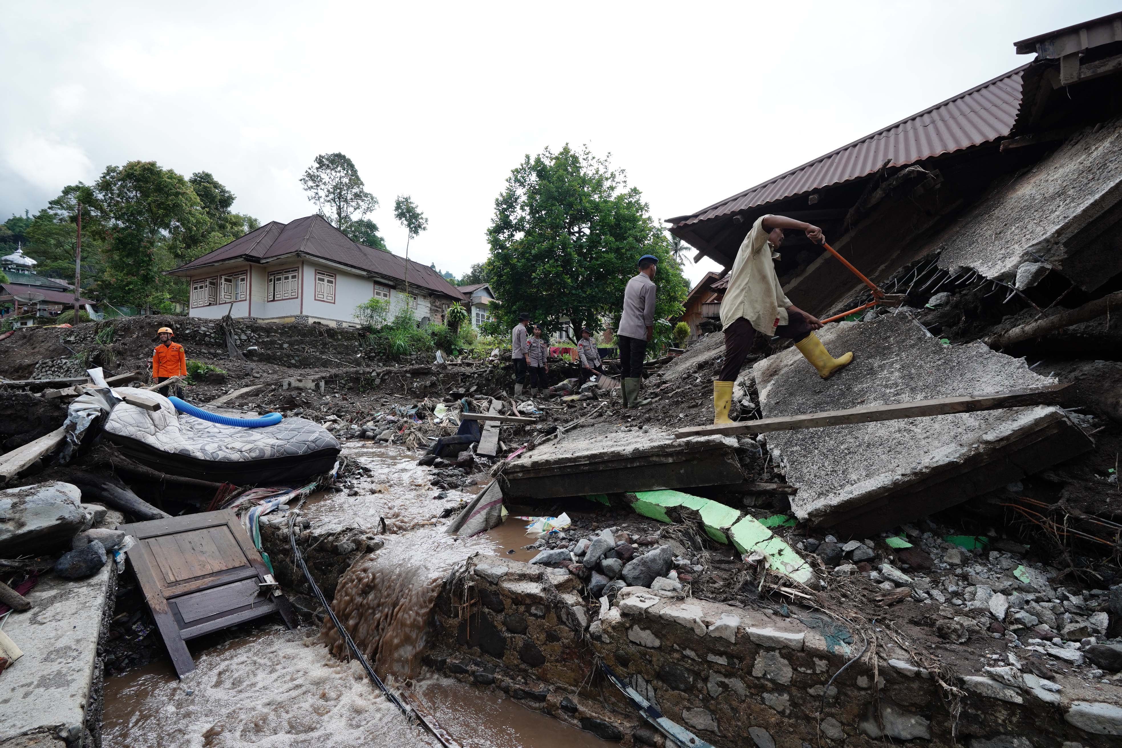 Petugas kepolisian bersama relawan melakukan pencarian korban banjir bandang dan tanah longsor di Kecamatan Malalak, Kabupaten Agam, Sumatera Barat, Minggu (7/12/2025). Sebanyak tiga dusun atau jorong di wilayah tersebut masih terisolir karena terputusnya akses jalan sehingga membuat distribusi logistik terhambat.