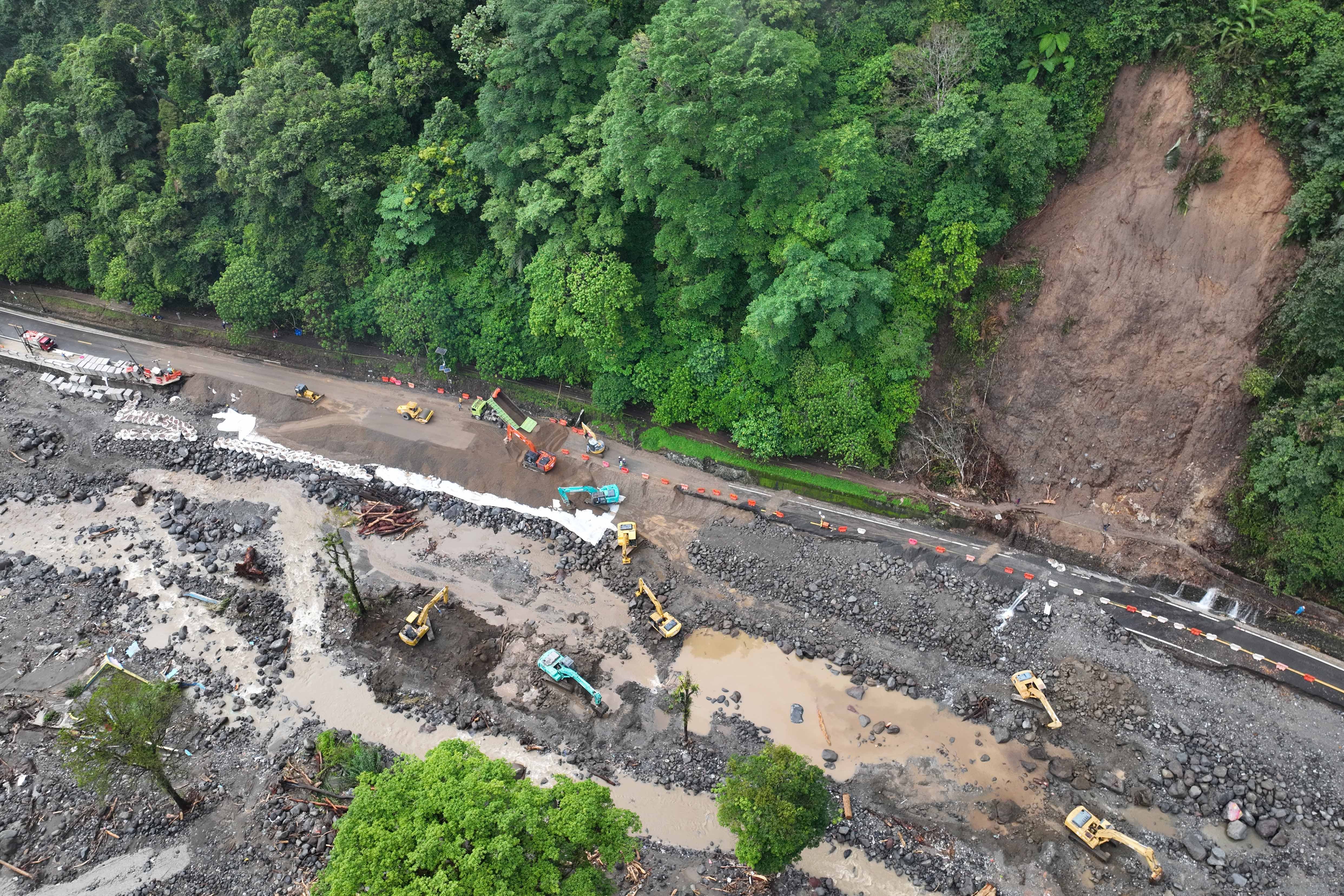 Puluhan alat berat bekerja membersihkan sisa longsor pemulihan akses jalan nasional di Lembah Anai, Sumatera Barat, Minggu (7/12/2025). Banjir bandang dan longsor yang menerjang jalan nasional itu pada Kamis (27/11) membuat akses jalan dari arah kota Padang terputus total.