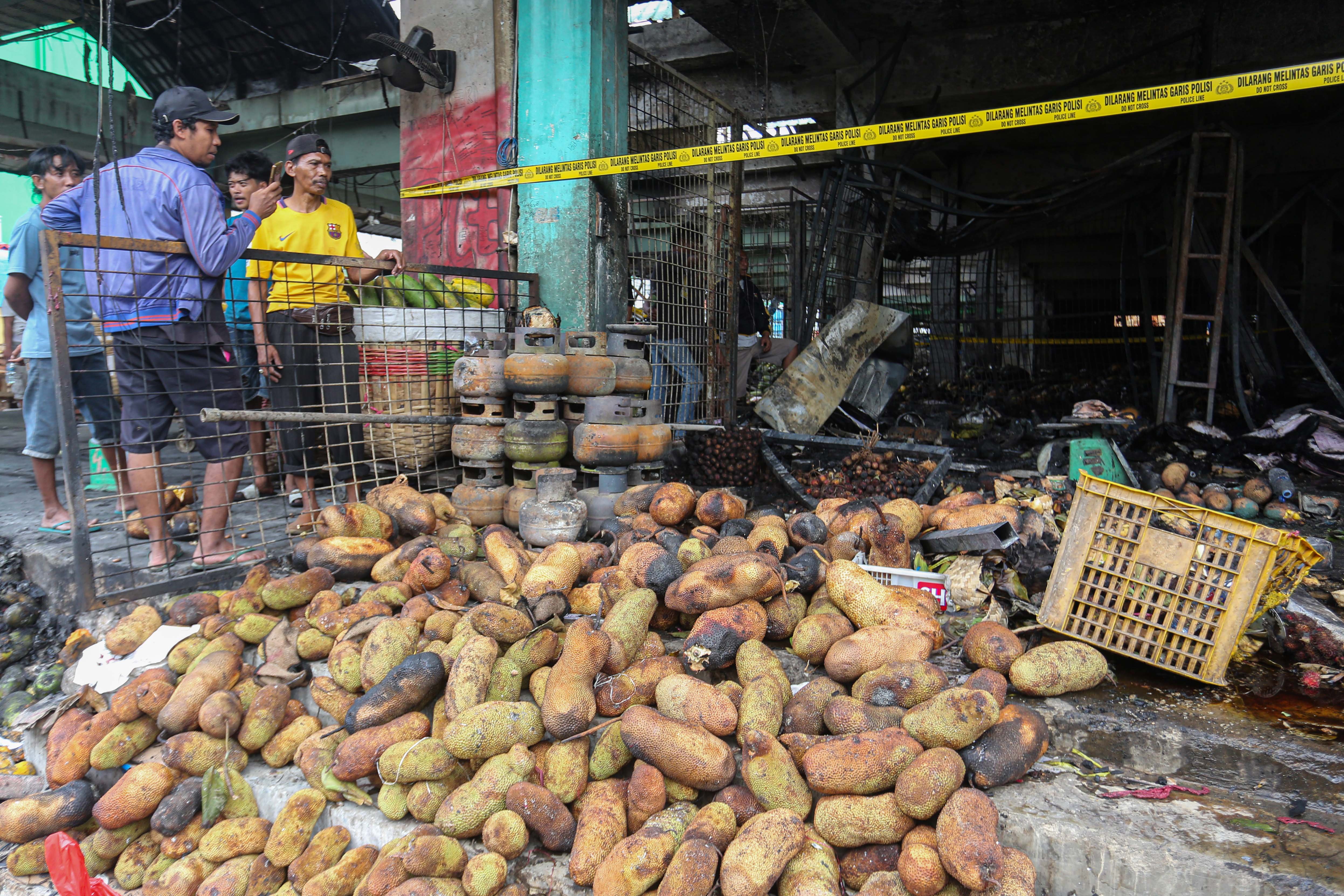 Pedagang melihat kios tempat berjualannya usai terbakar di Pasar Induk Kramat Jati, Jakarta Timur, Senin (15/12/2025). Kebakaran yang diduga akibat korsleting listrik tersebut menyebabkan 350 kios pedagang hangus terbakar dengan kerugian mencapai Rp10 miliar.