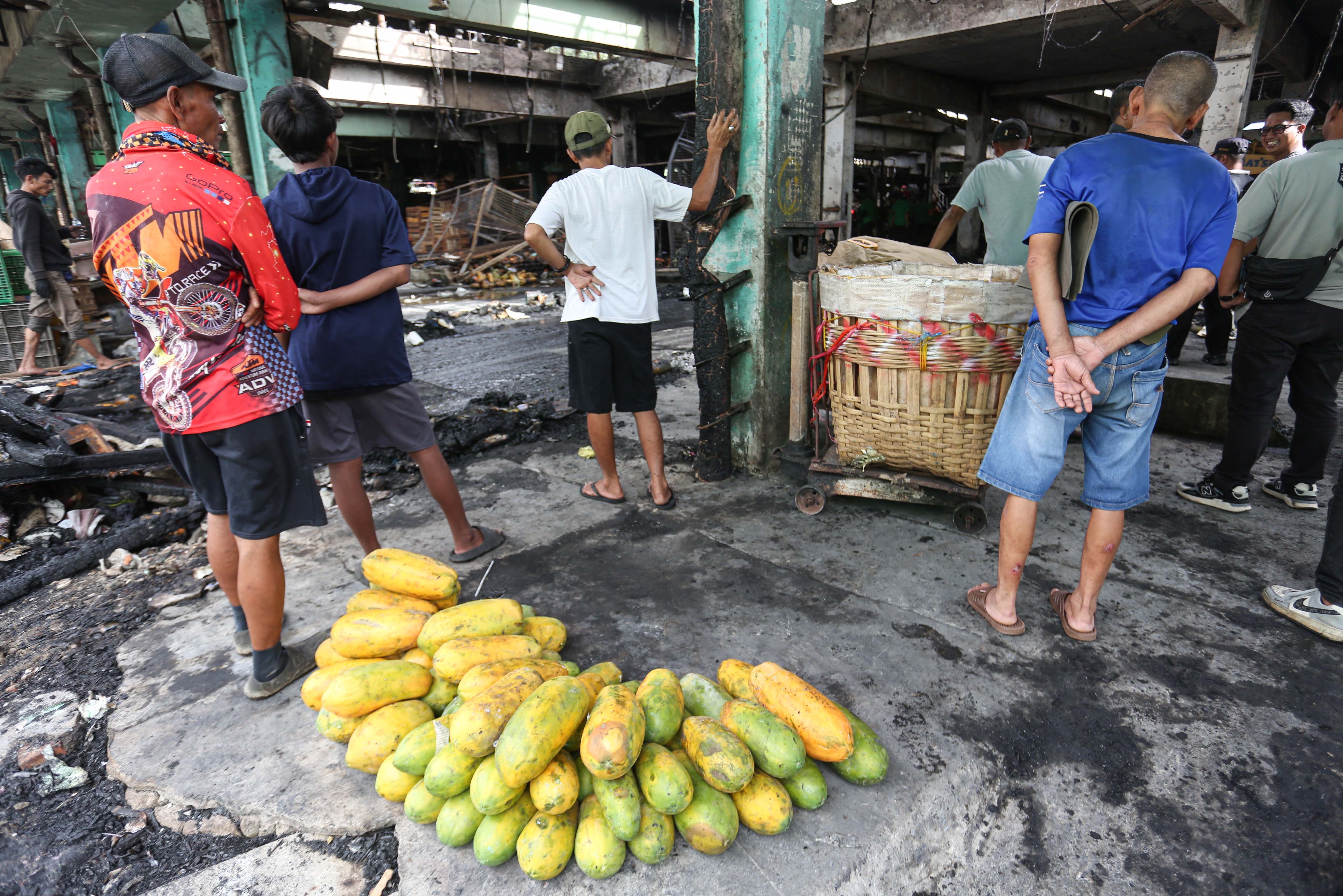 Pedagang melihat kios tempat berjualannya usai terbakar di Pasar Induk Kramat Jati, Jakarta Timur, Senin (15/12/2025). Kebakaran yang diduga akibat korsleting listrik tersebut menyebabkan 350 kios pedagang hangus terbakar dengan kerugian mencapai Rp10 miliar.
