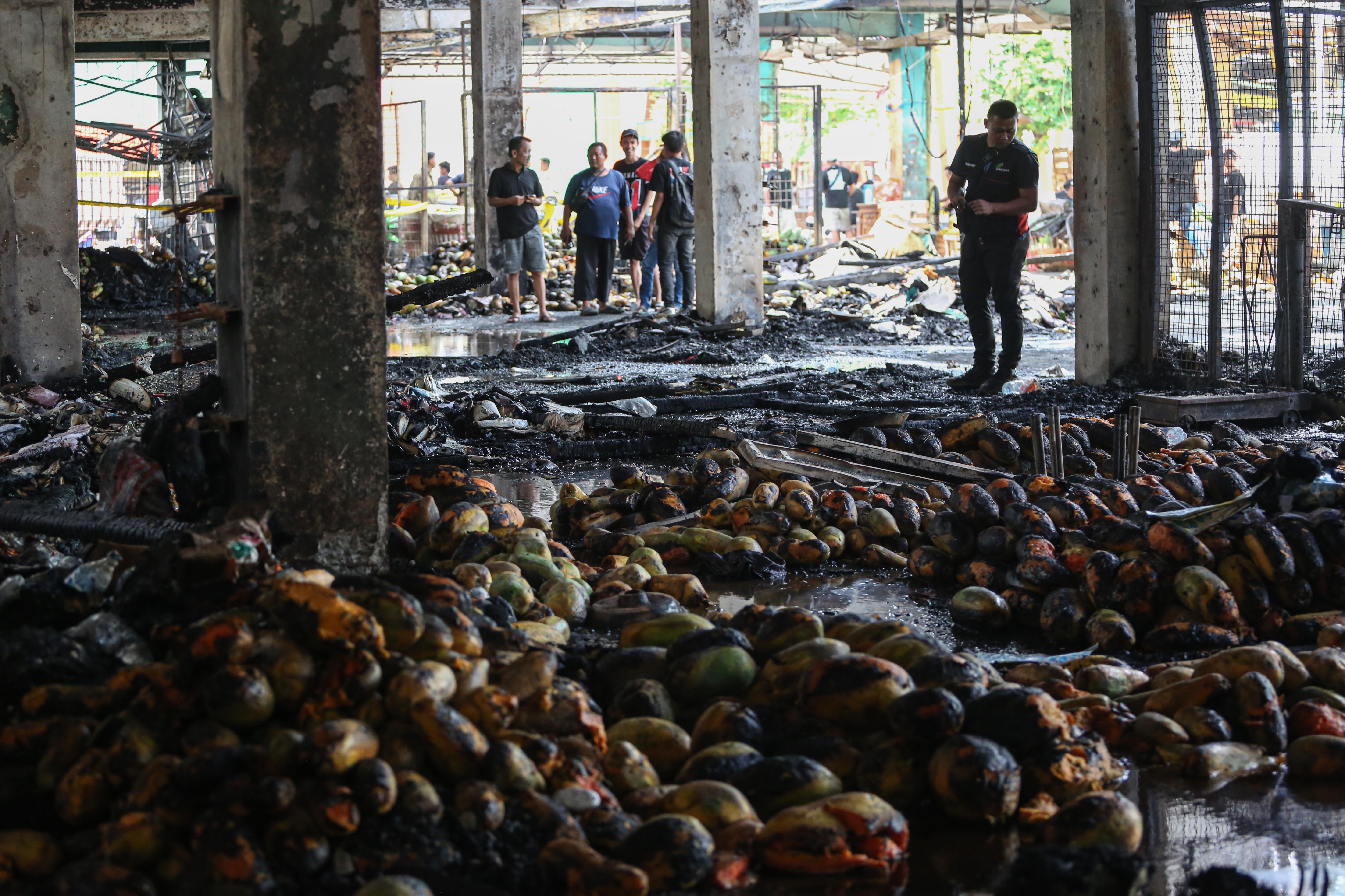 Pedagang melihat kios tempat berjualannya usai terbakar di Pasar Induk Kramat Jati, Jakarta Timur, Senin (15/12/2025). Kebakaran yang diduga akibat korsleting listrik tersebut menyebabkan 350 kios pedagang hangus terbakar dengan kerugian mencapai Rp10 miliar.