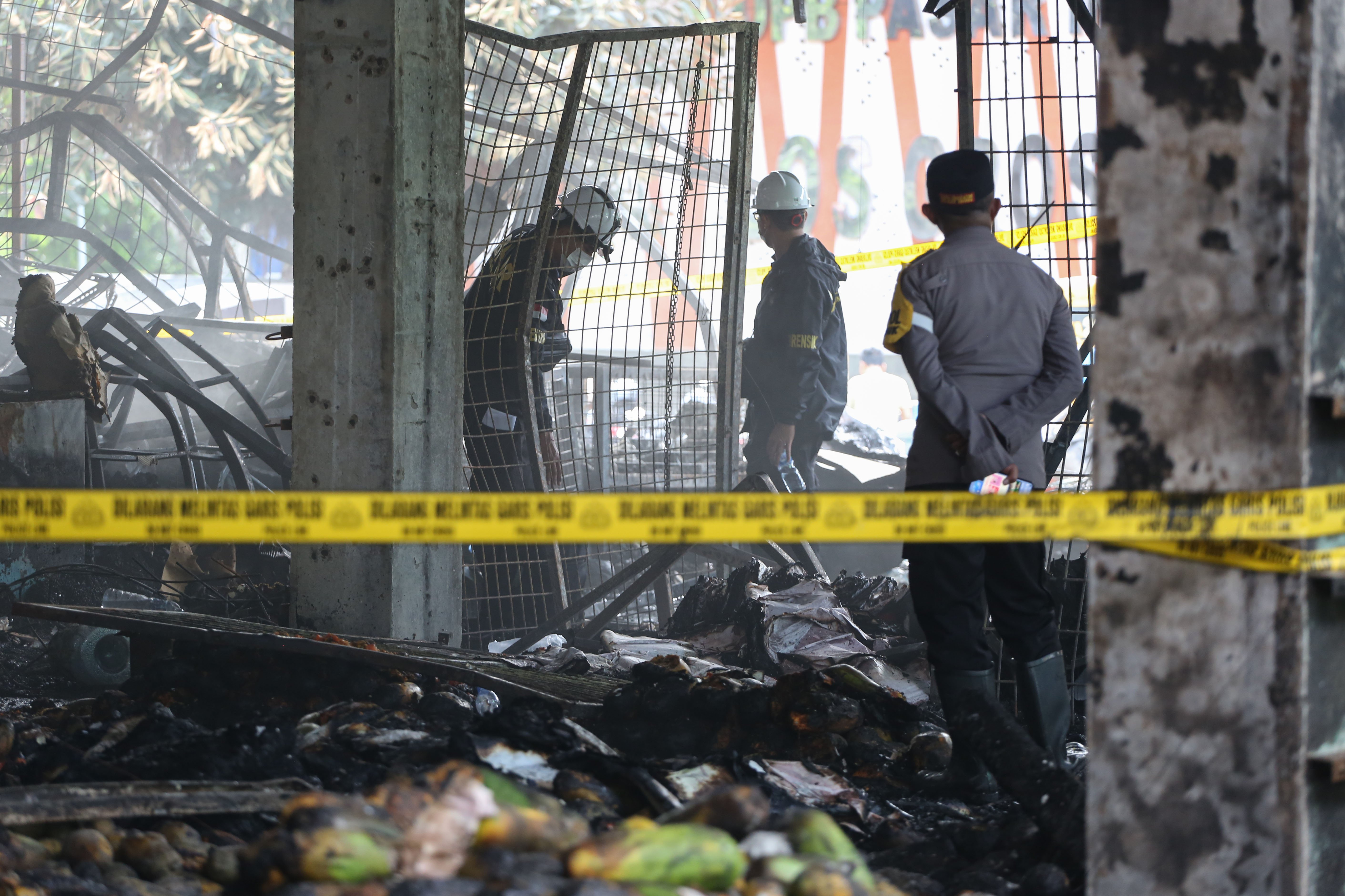 Petugas Pusat Laboratorium Forensik (Puslabfor) Bareskrim Polri melakukan olah tempat kejadian perkara terbakarnya kios pedagang di Pasar Induk Kramat Jati, Jakarta Timur, Senin (15/12/2025). Kebakaran yang diduga akibat korsleting listrik tersebut menyebabkan 350 kios pedagang hangus terbakar dengan kerugian mencapai Rp10 miliar.