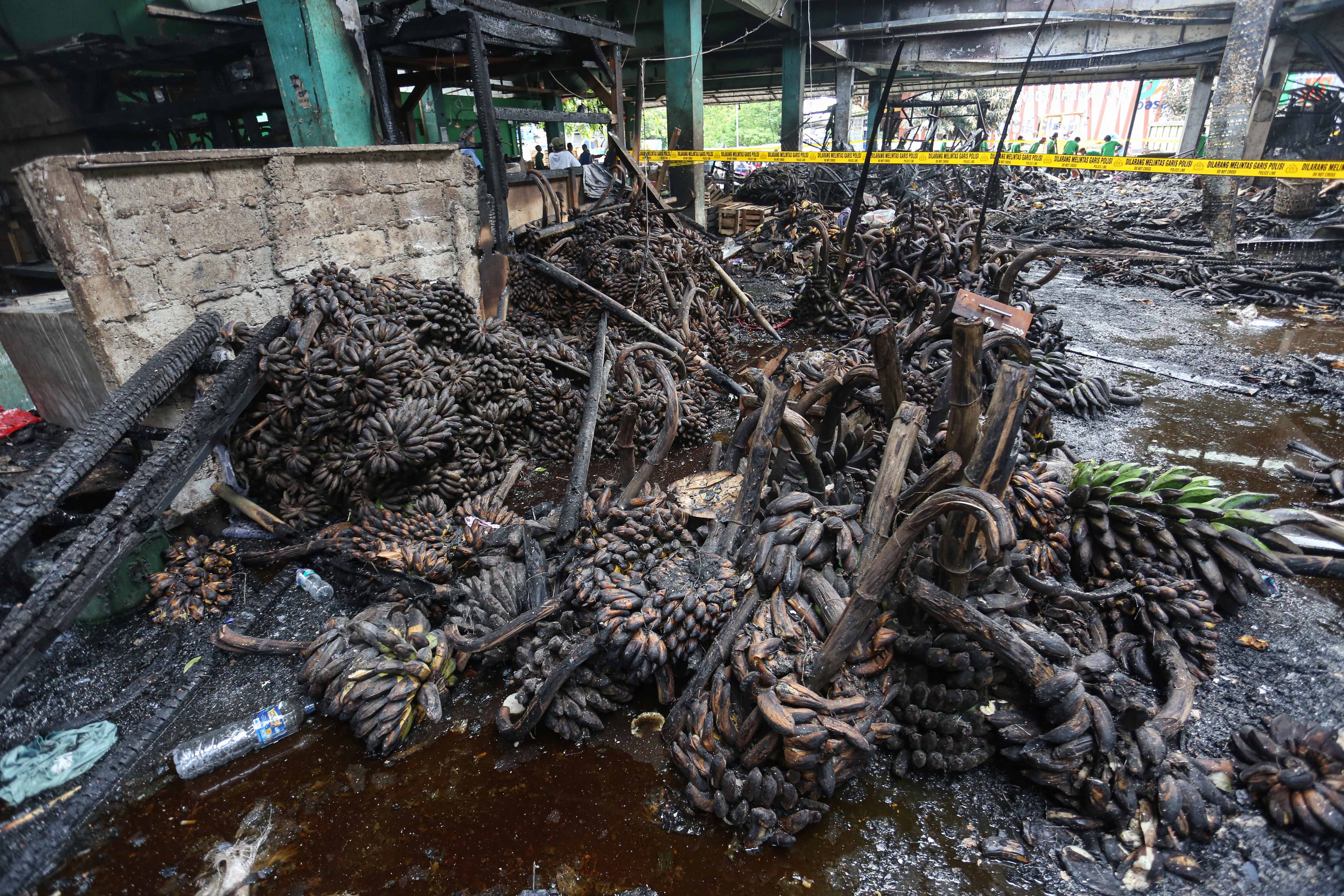 Buah pisang milik pedagang yang terbakar di Pasar Induk Kramat Jati, Jakarta Timur, Senin (15/12/2025). Kebakaran yang diduga akibat korsleting listrik tersebut menyebabkan 350 kios pedagang hangus terbakar dengan kerugian mencapai Rp10 miliar.